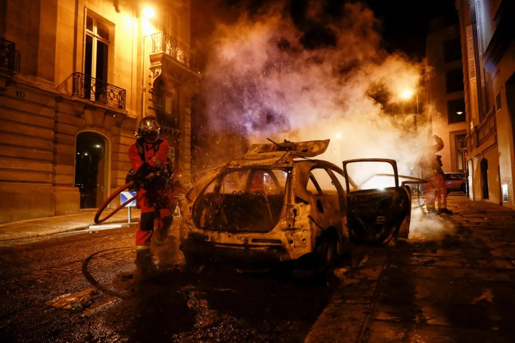 Los bomberos apagan un automóvil en llamas cerca de los Campos Elíseos en París el 23 de agosto de 2020, cuando los seguidores del PSG se reúnen después del partido de fútbol final de la UEFA Champions League entre el París Saint-Germain y el Bayern de Múnich en el estadio Luz de Lisboa. Foto: AFP