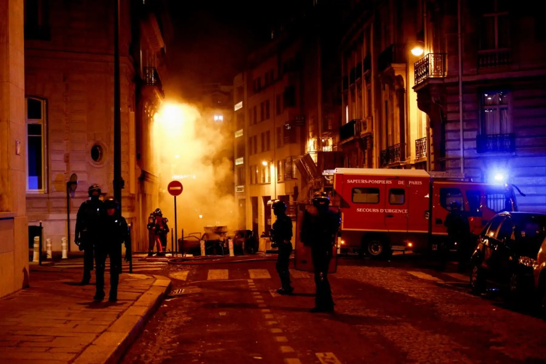 Los policías antidisturbios franceses de CRS están listos junto a los bomberos que apagan un incendio cerca de los Campos Elíseos en París el 23 de agosto de 2020, mientras los seguidores del PSG se reúnen después del partido de fútbol de la final de la UEFA Champions League entre el París Saint-Germain y el Bayern de Múnich en el Luz estadio en Lisboa. Foto: AFP