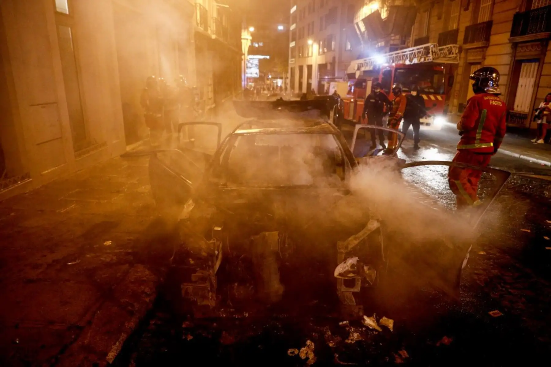 Los bomberos apagan un automóvil en llamas cerca de los Campos Elíseos en París el 23 de agosto de 2020, cuando los seguidores del PSG se reúnen después del partido de fútbol final de la UEFA Champions League entre el París Saint-Germain y el Bayern de Múnich en el estadio Luz de Lisboa. Foto: AFP
