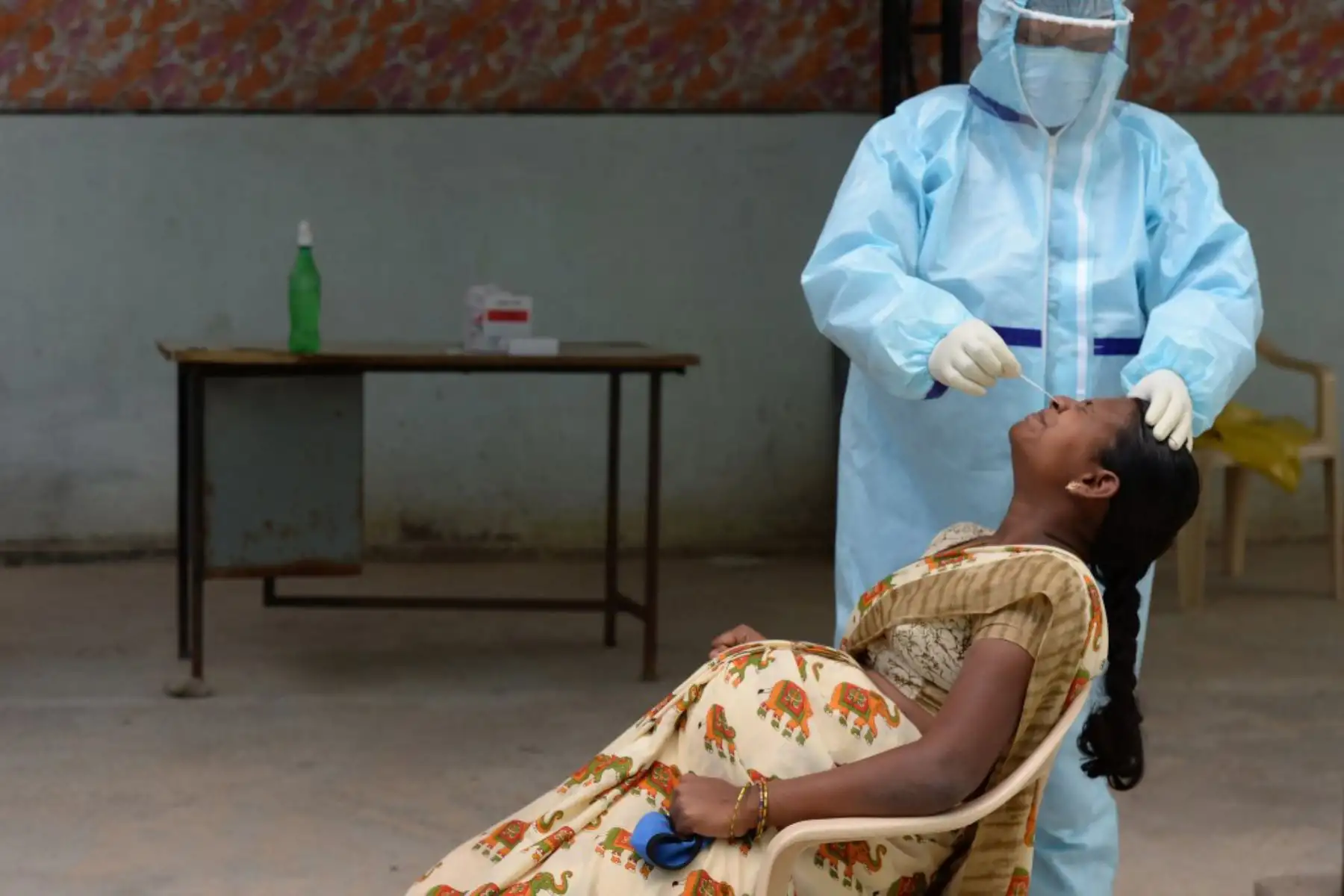Un trabajador de la salud que usa equipo de protección personal (EPP) recolecta una muestra de hisopo de una mujer embarazada en un centro gratuito de pruebas de coronavirusen el distrito de Medchal Malkajgiri en las afueras de Hyderabad, India. Los casos cruzaron la marca de los tres millones con casi 70.000 nuevas infecciones, mientras la enfermedad continúa aumentando en la segunda nación más poblada del mundo. 

Foto: AFP