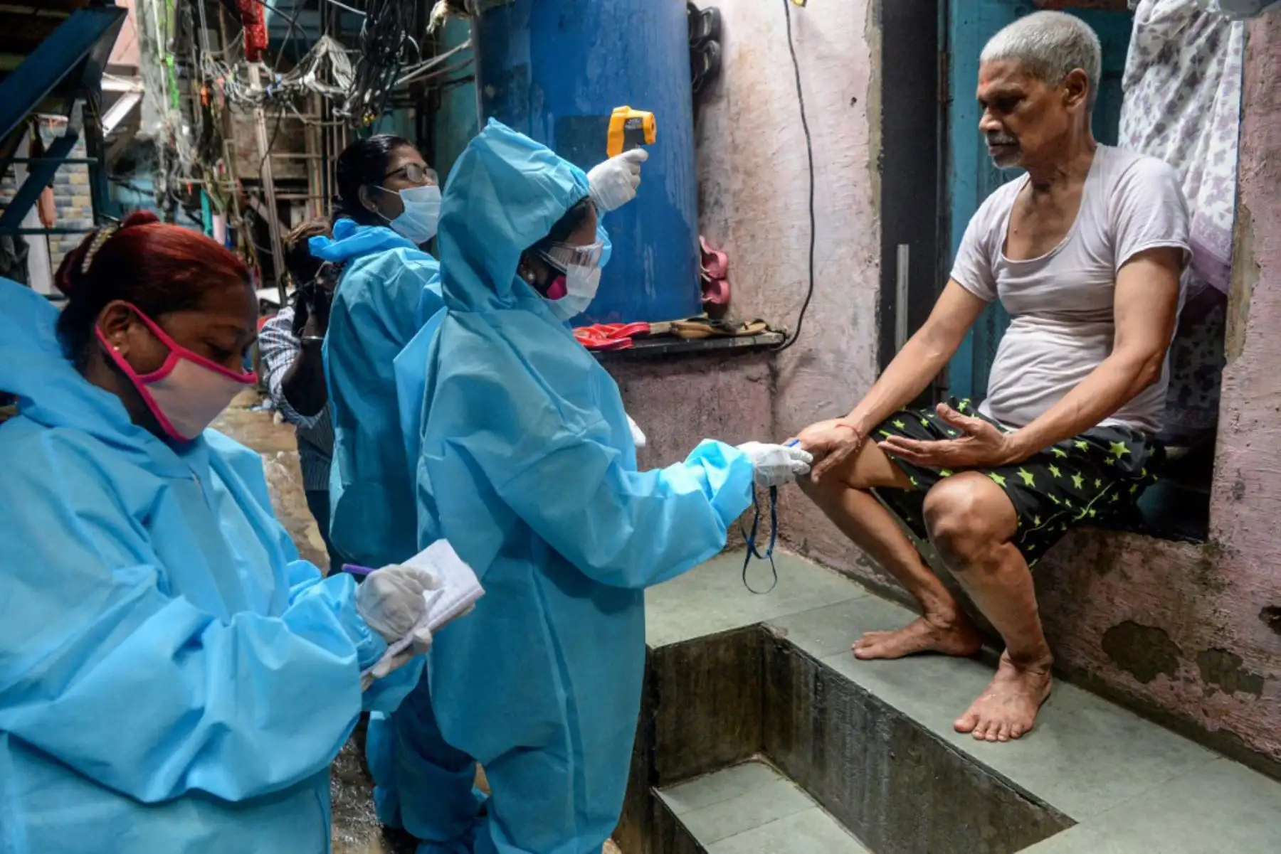 Trabajadores de la salud que usan equipos de protección personal (EPP) usan un oxímetro de pulso de la yema del dedo y controlan la temperatura corporal de un residente dentro del barrio pobre de Dharavi durante una prueba de detección del coronavirus puerta a puerta en Mumbai. Los casos de coronavirus en India cruzaron la marca de los tres millones con casi 70.000 nuevas infecciones, mientras la enfermedad continúa aumentando en la segunda nación más poblada del mundo. 

Foto: AFP