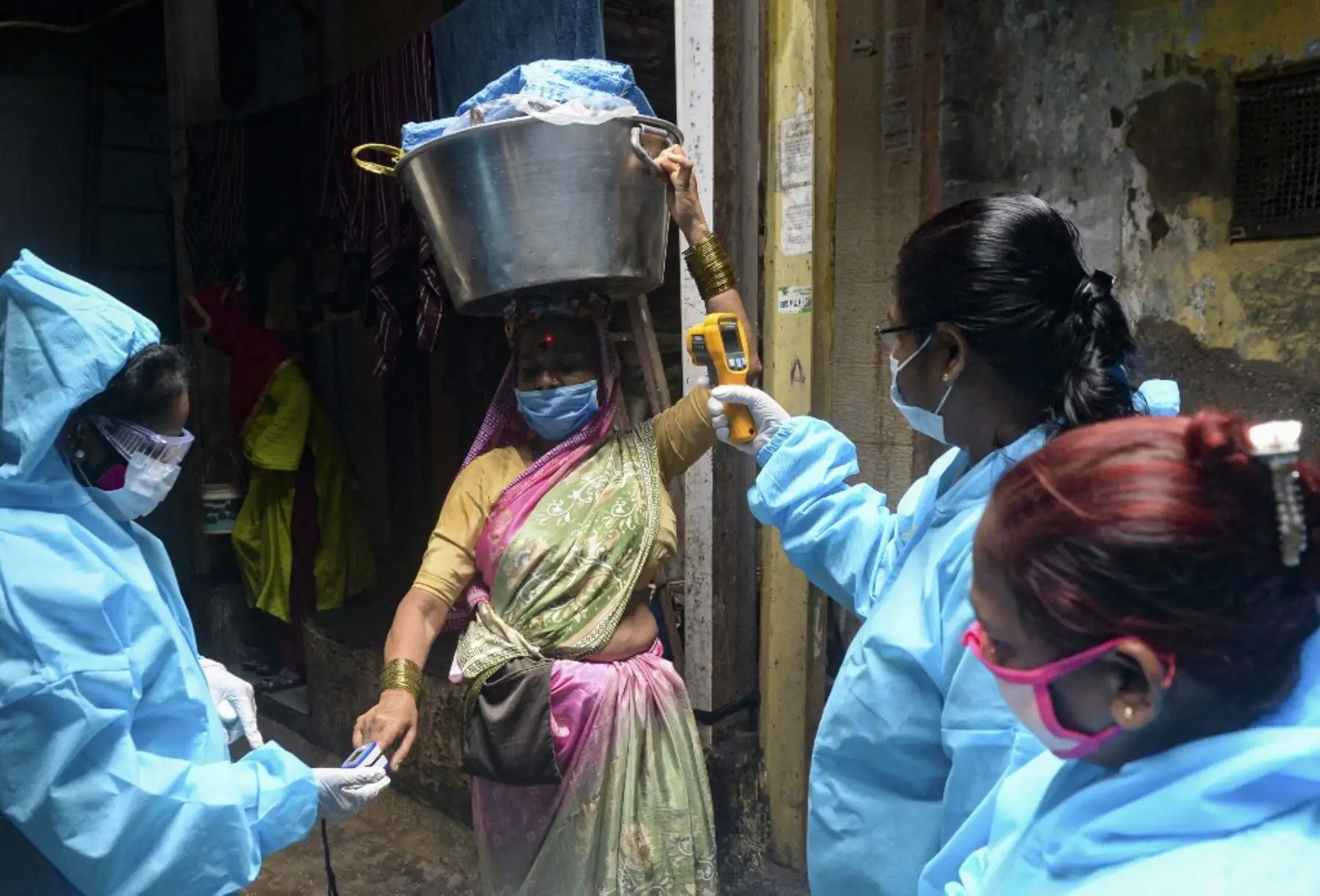 Trabajadores de la salud que usan equipos de protección personal (EPP) usan un oxímetro de pulso de la yema del dedo y controlan la temperatura corporal de una pescadora dentro del barrio pobre de Dharavi durante una prueba de detección del coronavirus puerta a puerta en Mumbai. En India, los casos cruzaron la marca de los tres millones con casi 70.000 nuevas infecciones, mientras la enfermedad continúa aumentando en la segunda nación más poblada del mundo. 

Foto :AFP