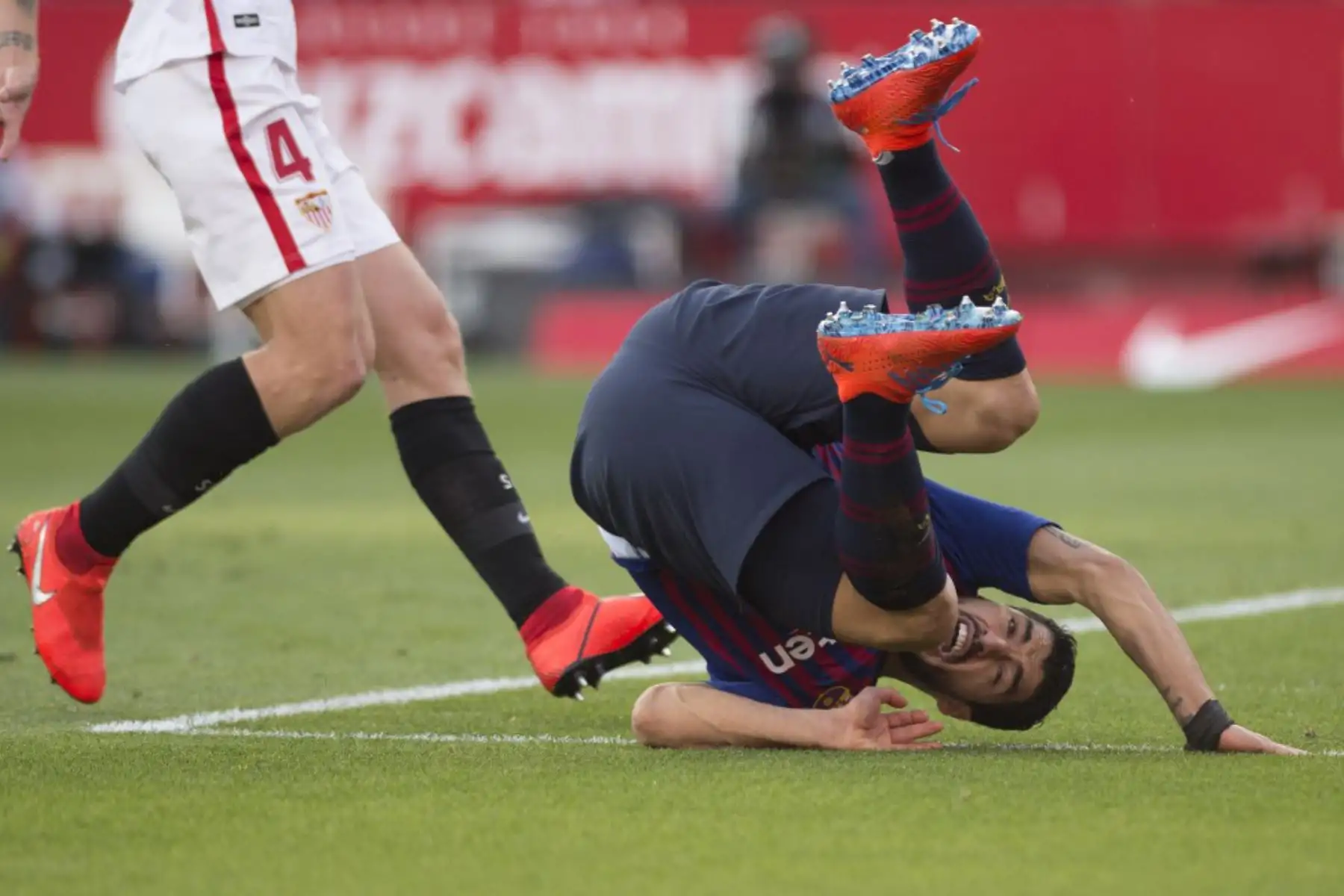 El delantero uruguayo del Barcelona Luis Suárez cae durante el partido de fútbol de la liga española entre el Sevilla FC y el FC Barcelona en el estadio Ramón Sánchez Pizjuán de Sevilla.

Foto: AFP