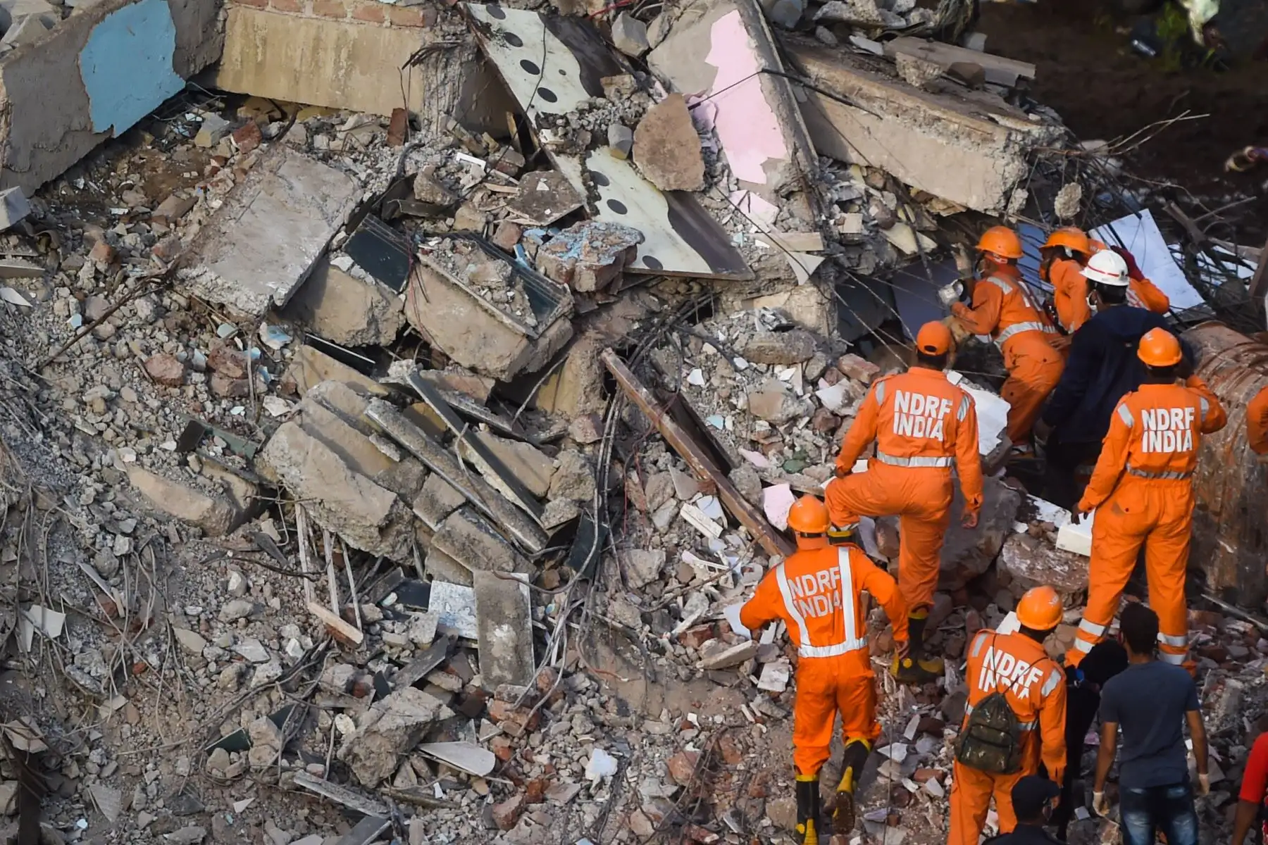 Trabajadores de rescate buscan personas entre los escombros de un edificio de apartamentos de cinco pisos colapsado en Mahad, India, el 25 de agosto de 2020. Foto: AFP