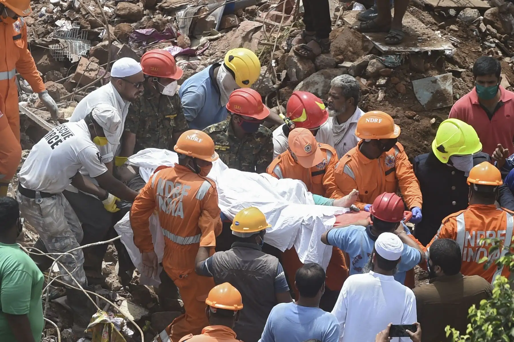 Los equipos de rescate llevan el cuerpo de una víctima que murió después de que un edificio de apartamentos de cinco pisos se derrumbara en Mahad, India, el 25 de agosto de 2020. Foto: AFP