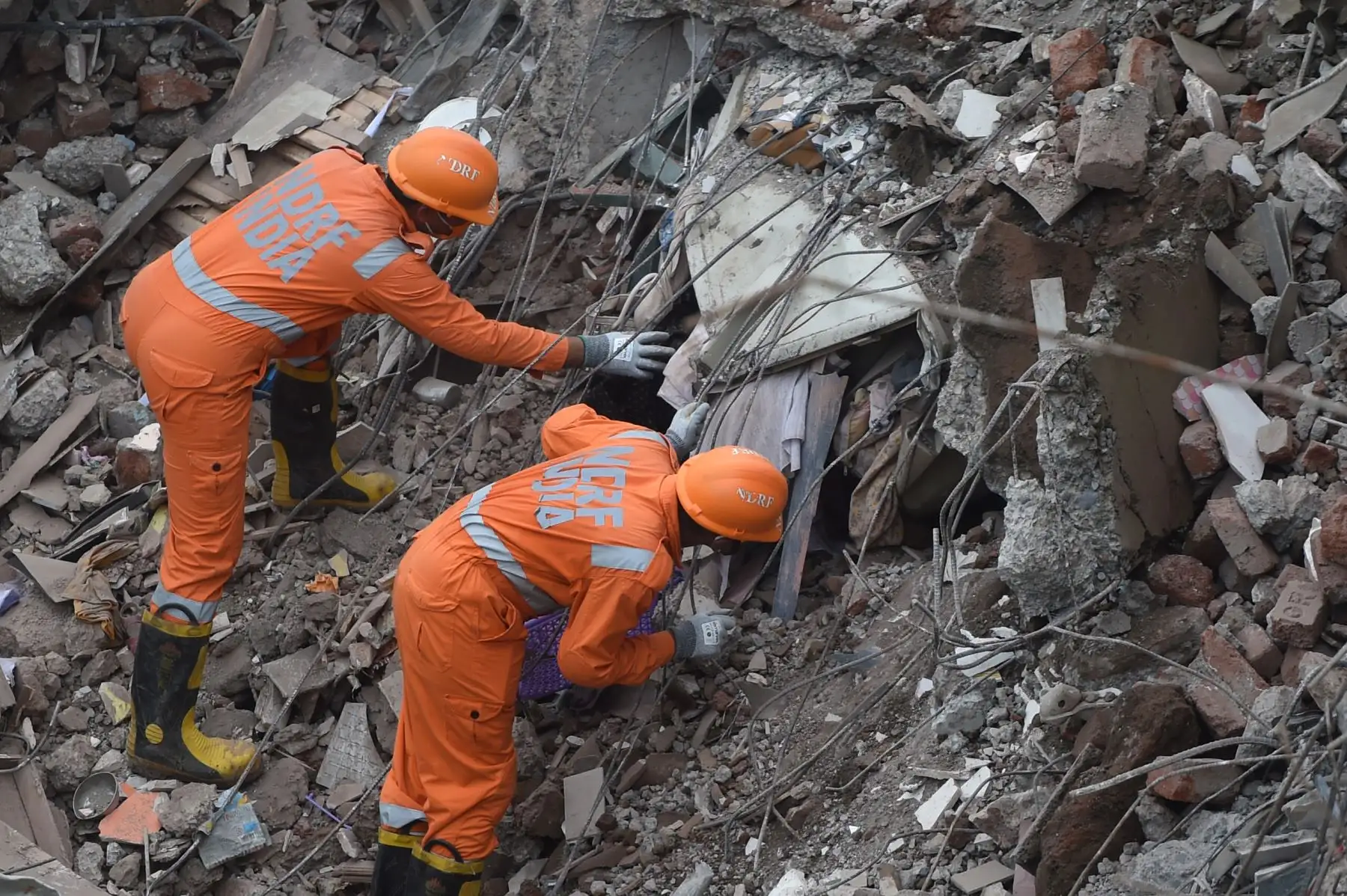Trabajadores de rescate buscan personas entre los escombros de un edificio de apartamentos de cinco pisos colapsado en Mahad, India, el 25 de agosto de 2020. Foto: AFP