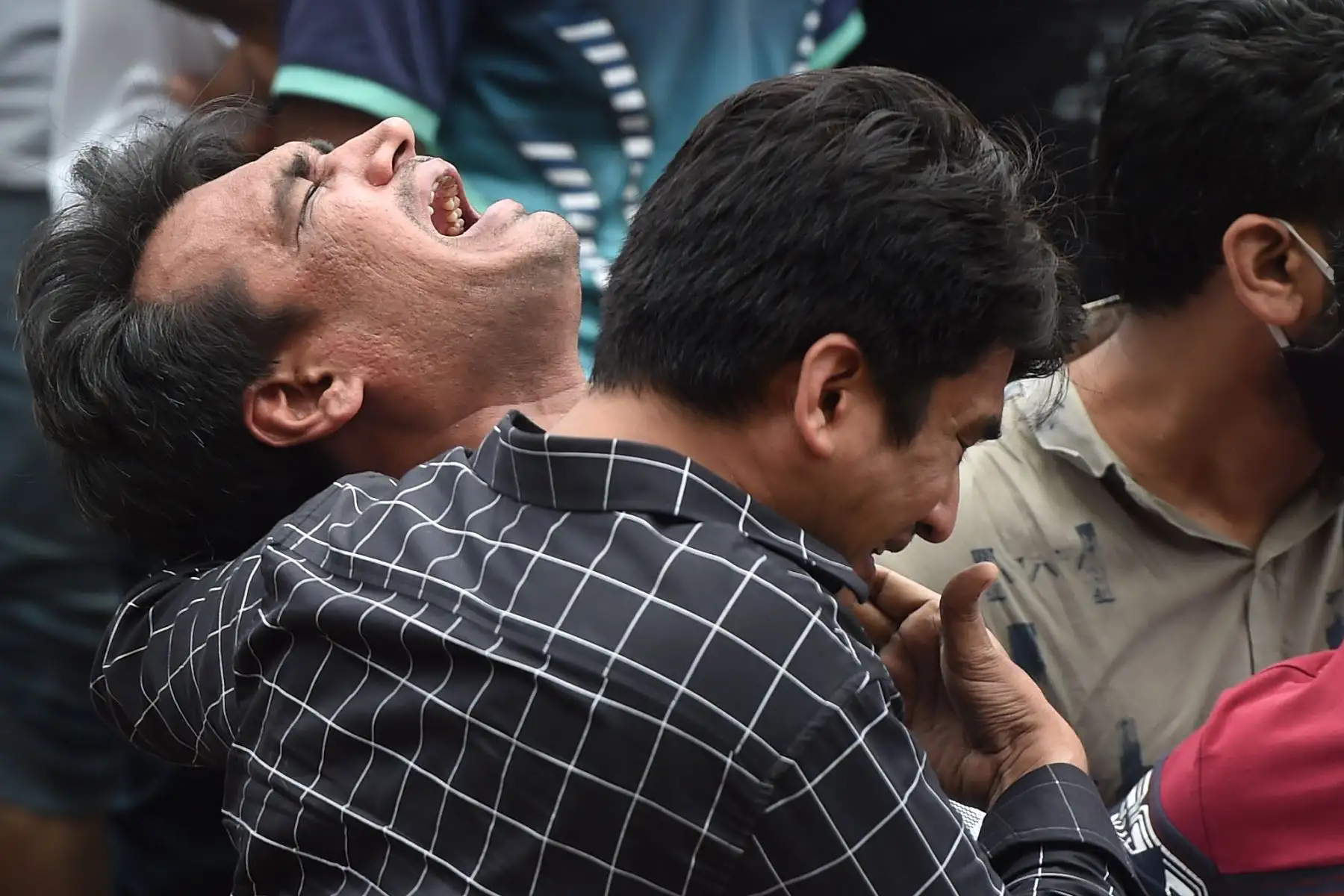 Familiares lamentan la muerte de una víctima que murió después de que un edificio de apartamentos de cinco pisos se derrumbó en Mahad, Inidia, el 25 de agosto de 2020. Foto: AFP