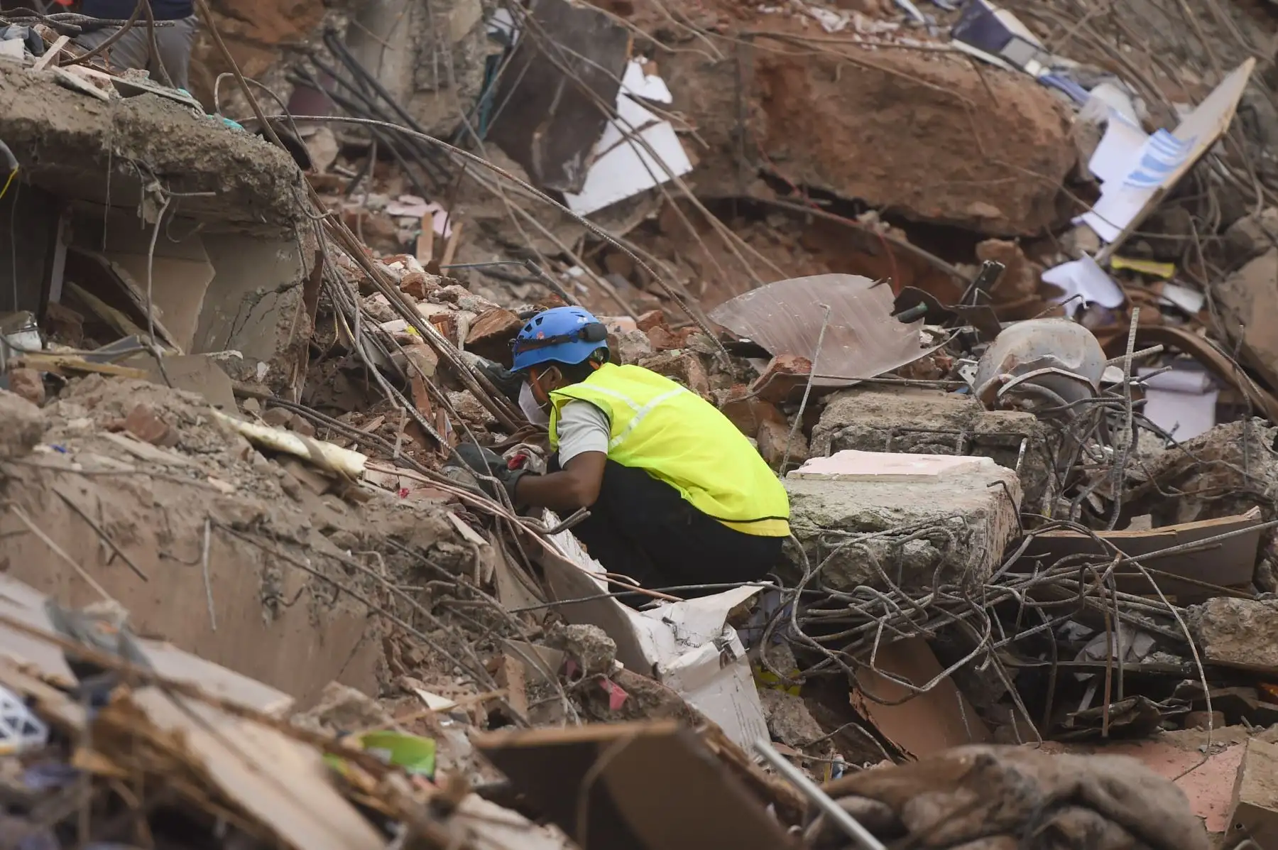 Un rescatista busca personas entre los escombros de un edificio de apartamentos de cinco pisos después de que se derrumbó en Mahad el 25 de agosto de 2020. Foto: AFP