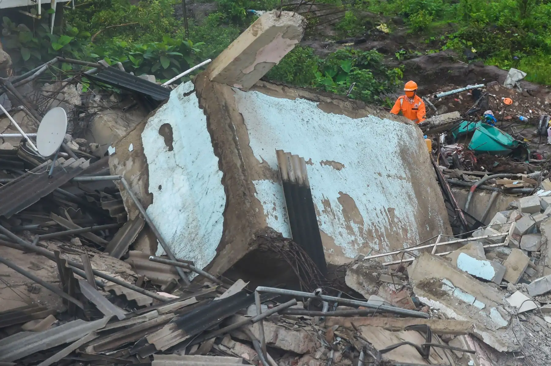 Un rescatista trata de ubicar personas entre los escombros de un edificio de apartamentos de cinco pisos después de que se derrumbó en Mahad, India, el 25 de agosto de 2020. Foto: AFP