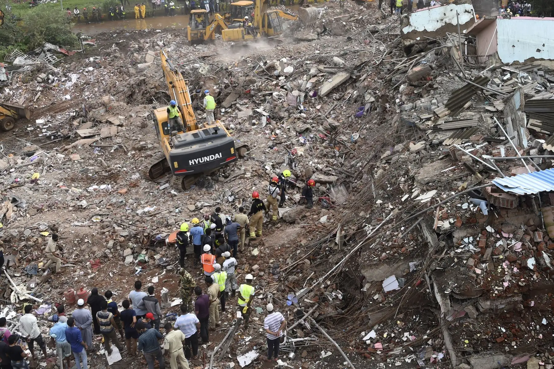 Los equipos de rescate continúan buscando sobrevivientes entre los escombros de un edificio de apartamentos de cinco pisos que se derrumbó, en Mahad, India, el 25 de agosto de 2020. Foto: AFP