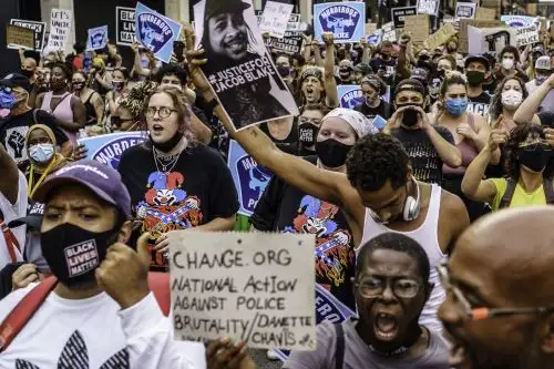 Manifestantes marchan cerca de la primera comisaría de policía de Minneapolis durante una manifestación contra la brutalidad policial y el racismo en Minnesota. Fue el segundo día de manifestaciones en Kenosha, después de que el domingo circuló un video que mostraba el tiroteo de Jacob Blake por siete veces, de espaldas, mientras trataba de entrar en su automóvil, con sus tres hijos menores mirando. Foto: AFP.
