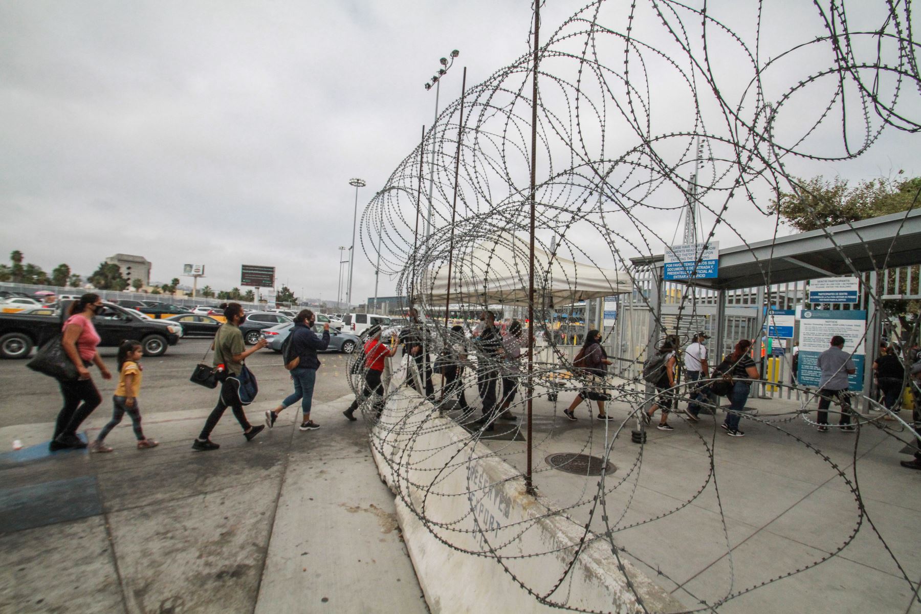 Personas portan mascarillas mientras hacen fila para ingresar a pie hacia Estados Unidos en la garita del cruce fronterizo Tijuana-San Ysidro, en Tijuana, México. Foto: Xinhua