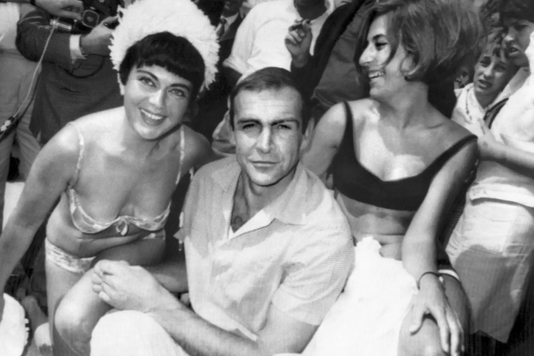 El actor Sean Connery, acompañado por dos visitantes de verano, posa el 22 de mayo de 1965 durante el Festival Internacional de Cine de Cannes. Foto :AFP