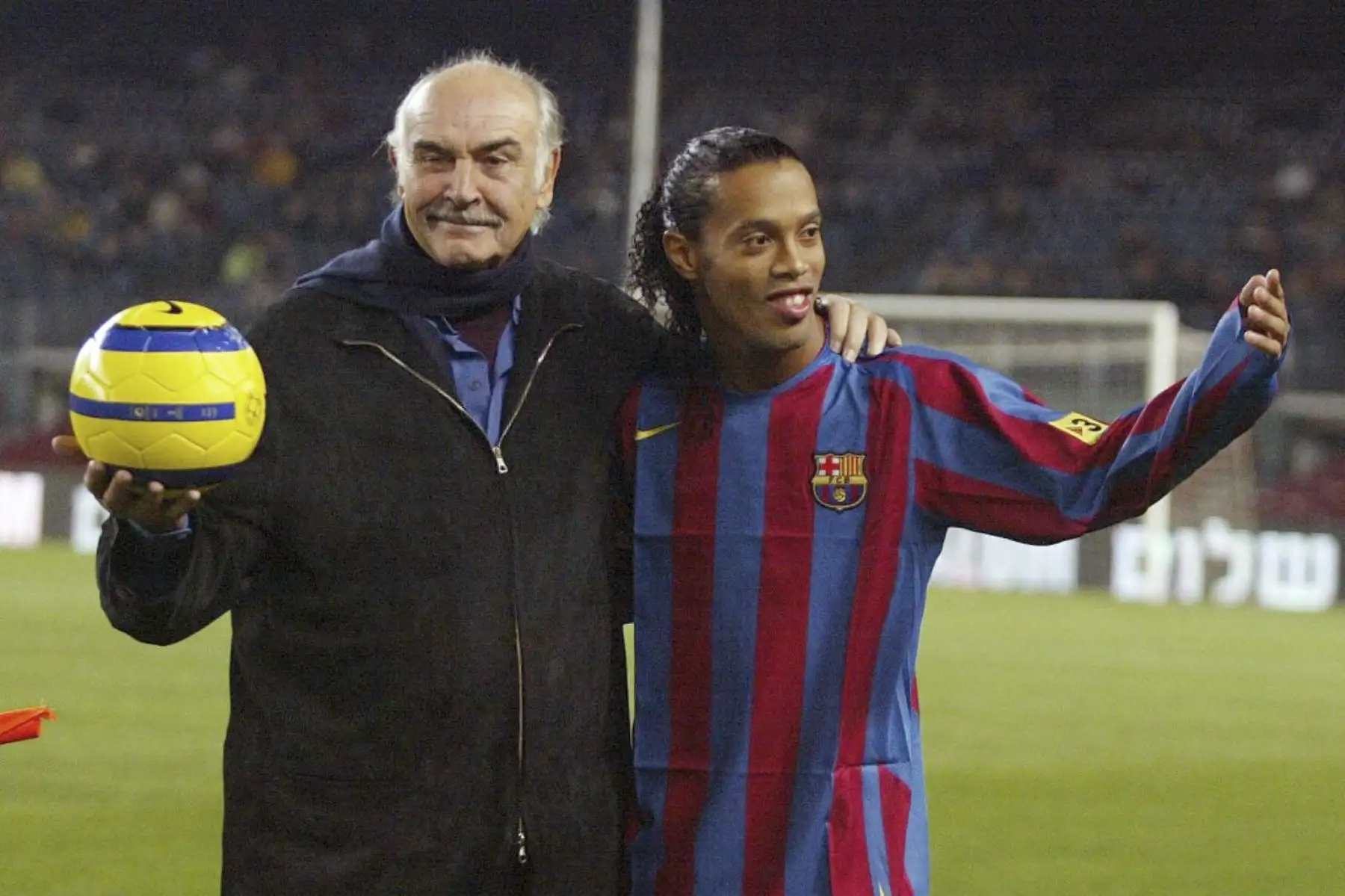 El actor británico Sean Connery junto al jugador brasileño Ronaldinho después de hacer un saque inicial durante el "Partido por la Paz" en el estadio Camp Nou de Barcelona, ​​29 de noviembre de 2005.Foto:AFP