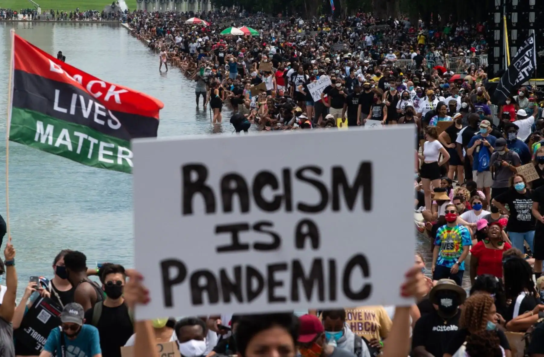 Los manifestantes sostienen carteles y banderas durante la protesta "Marcha de compromiso: quítese las rodillas del cuello" contra el racismo y la brutalidad policial, en Washington, DC. Manifestantes antirracistas marcharon por las calles de la capital estadounidense el viernes, luego de que un oficial blanco disparara contra el afroamericano Jacob Blake. Foto:AFP