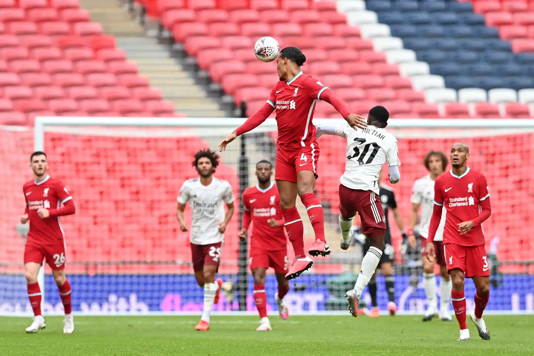 El defensor holandés de Liverpool, Virgil van Dijk, salta para cabecear el balón junto al delantero inglés del Arsenal, Eddie Nketiah, durante el partido de fútbol English FA Community Shield. Foto: AFP