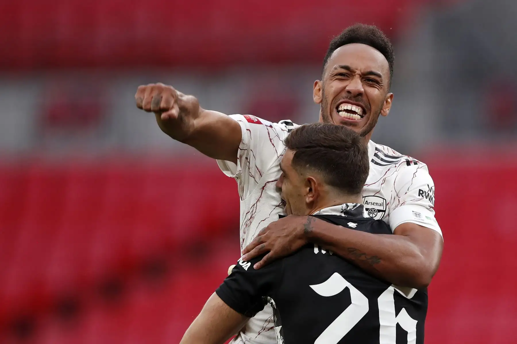 El delantero gabonés del Arsenal, Pierre-Emerick Aubameyang, celebra tras anotar el penalti ganador junto all portero de su equipo, Emiliano Martínez. Foto: AFP