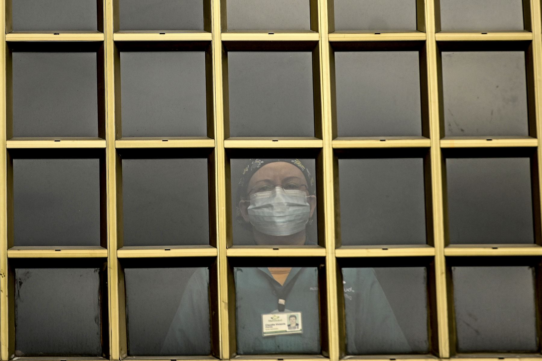 Un trabajador de la salud observa desde la ventana de un hospital en Medellín, Colombia, en medio de la pandemia de covid-19. Foto: AFP