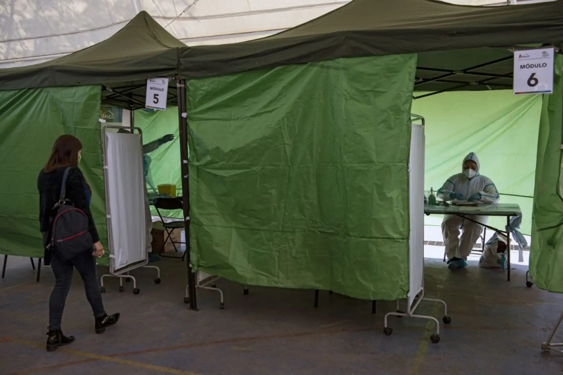 Una mujer camina hacia una carpa médica para someterse a una prueba de PCR para el nuevo coronavirus en un puesto de control en el municipio de Renca, Santiago de Chile. Foto: AFP