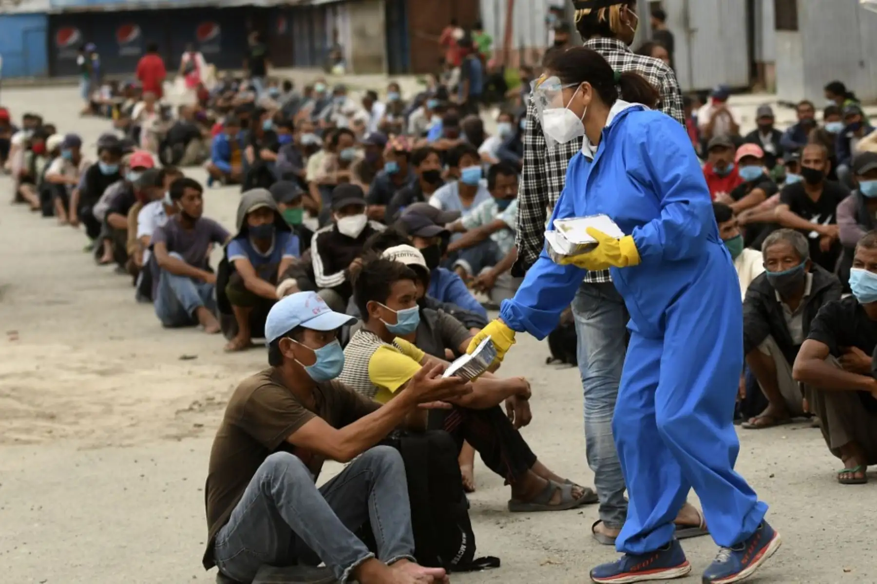 Los voluntarios distribuyen paquetes de alimentos a las personas necesitadas después de que los funcionarios del distrito impusieron restricciones de una semana para contener la propagación del coronavirus covid-19, en Katmandú. Foto: AFP