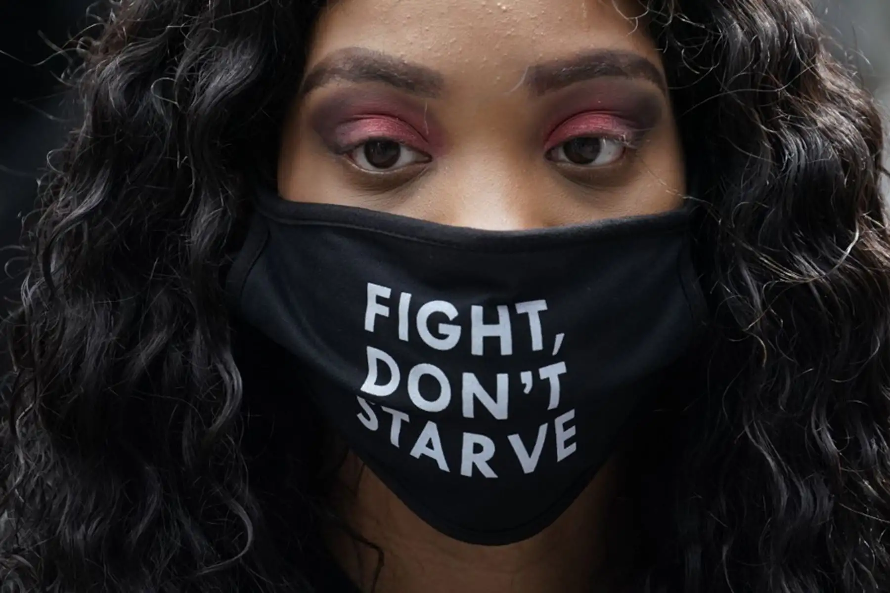 Un manifestante usa una mascarilla "Fight Don