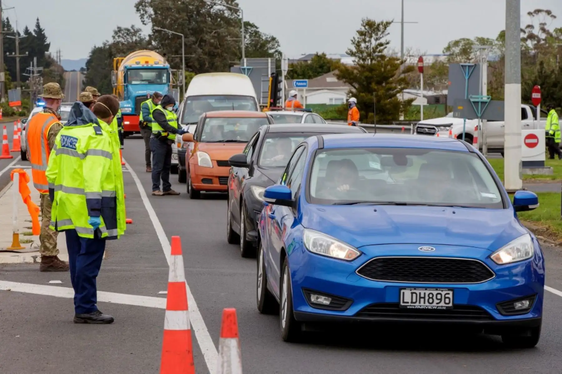 La policía y el personal militar revisan los vehículos que salen de la ciudad en un punto de control covid-19 configurado en el límite sur de Auckland. Foto: AFP