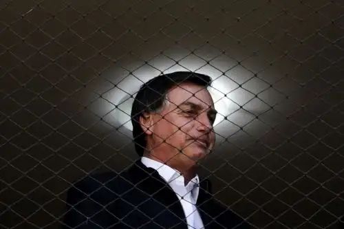 En esta imagen de archivo tomada el 23 de agosto de 2020, el presidente brasileño Jair Bolsonaro mira por la ventana de la residencia de un asesor en Brasilia. Foto: AFP