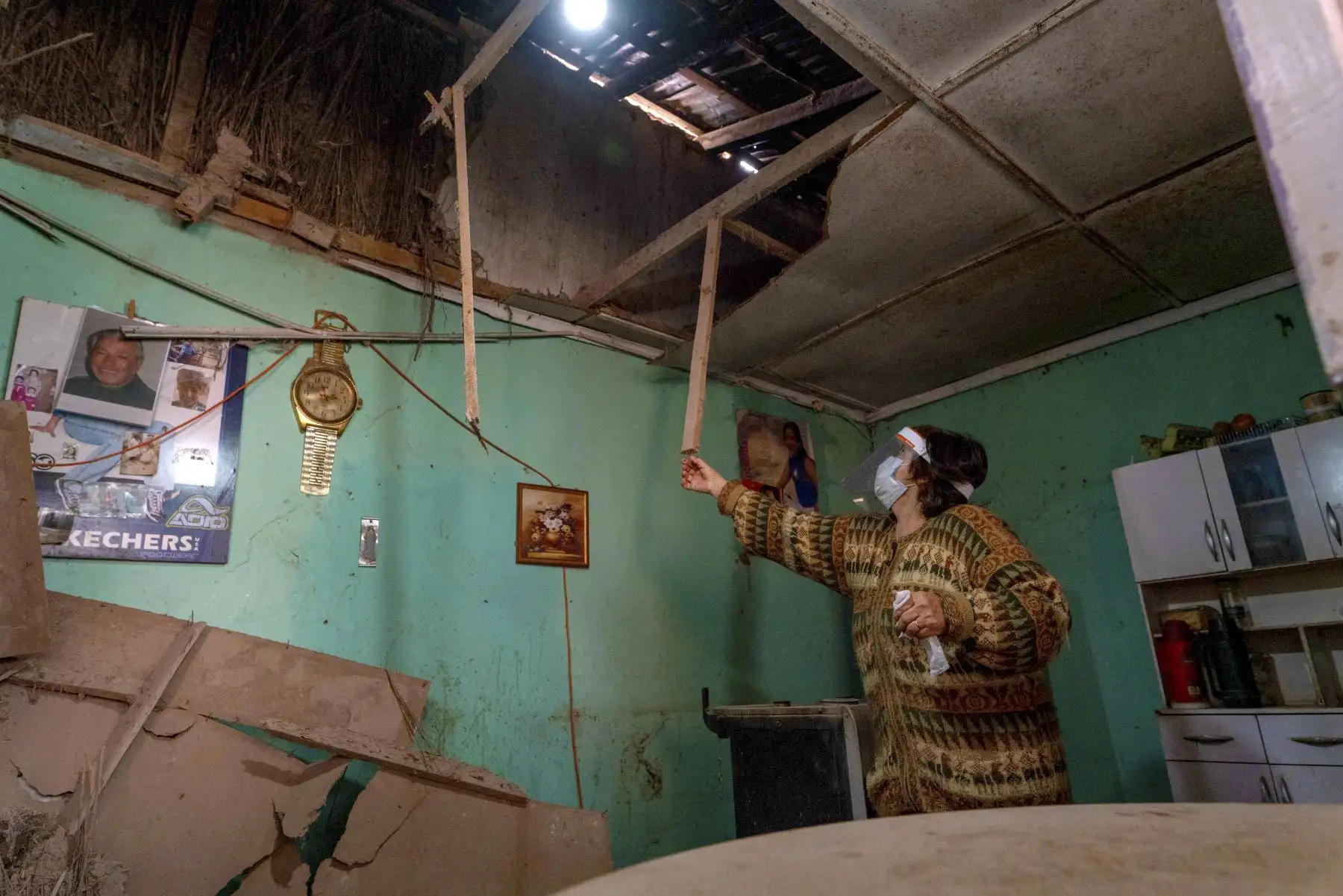 Una mujer muestra el techo dañado de su casa en Copiapó, norte de Chile luego de un terremoto de magnitud de 7 grados. Un poderoso terremoto sacudió la costa del norte de Chile el martes temprano, pero no hubo alerta de tsunami y el terremoto causó daños estructurales relativamente menores, dijeron las autoridades. Foto: AFP