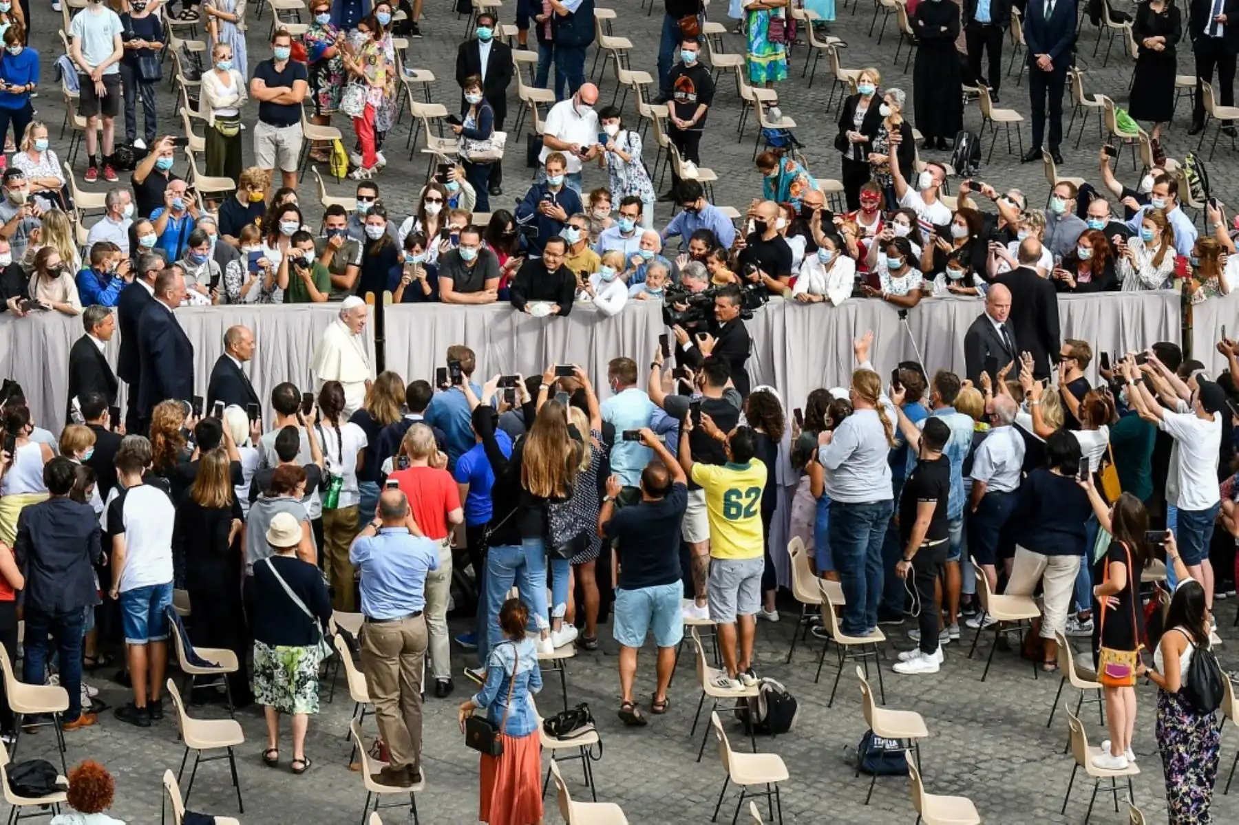 Los asistentes saludan al Papa Francisco, cuando llega para realizar una audiencia pública limitada en el patio de San Damaso en el Vaticano. Foto:AFP