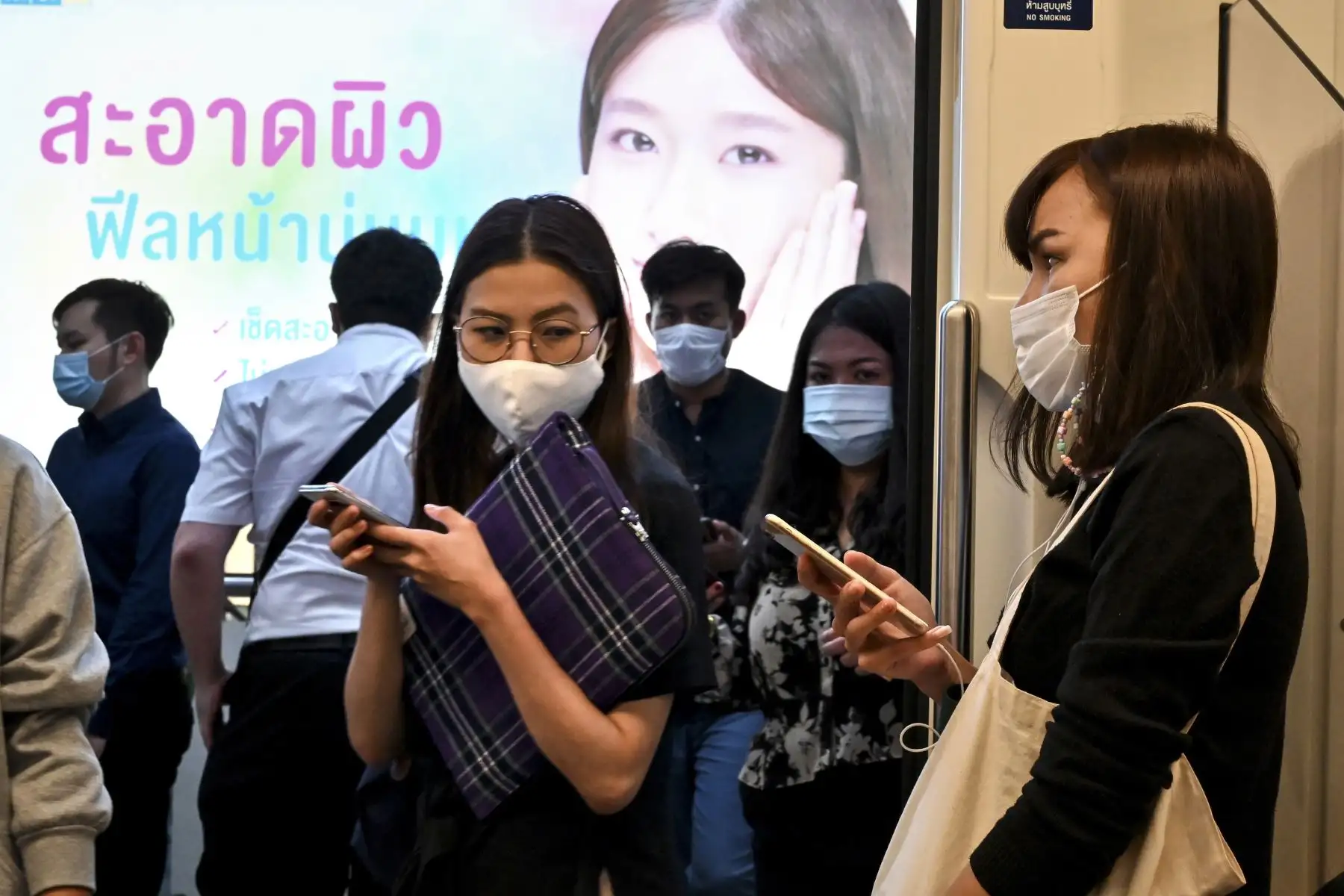 Pasajeros con máscaras faciales en medio de preocupaciones por la propagación del nuevo coronavirus COVID-19 abordan un tren de cercanías en BangkoK.
Foto: AFP