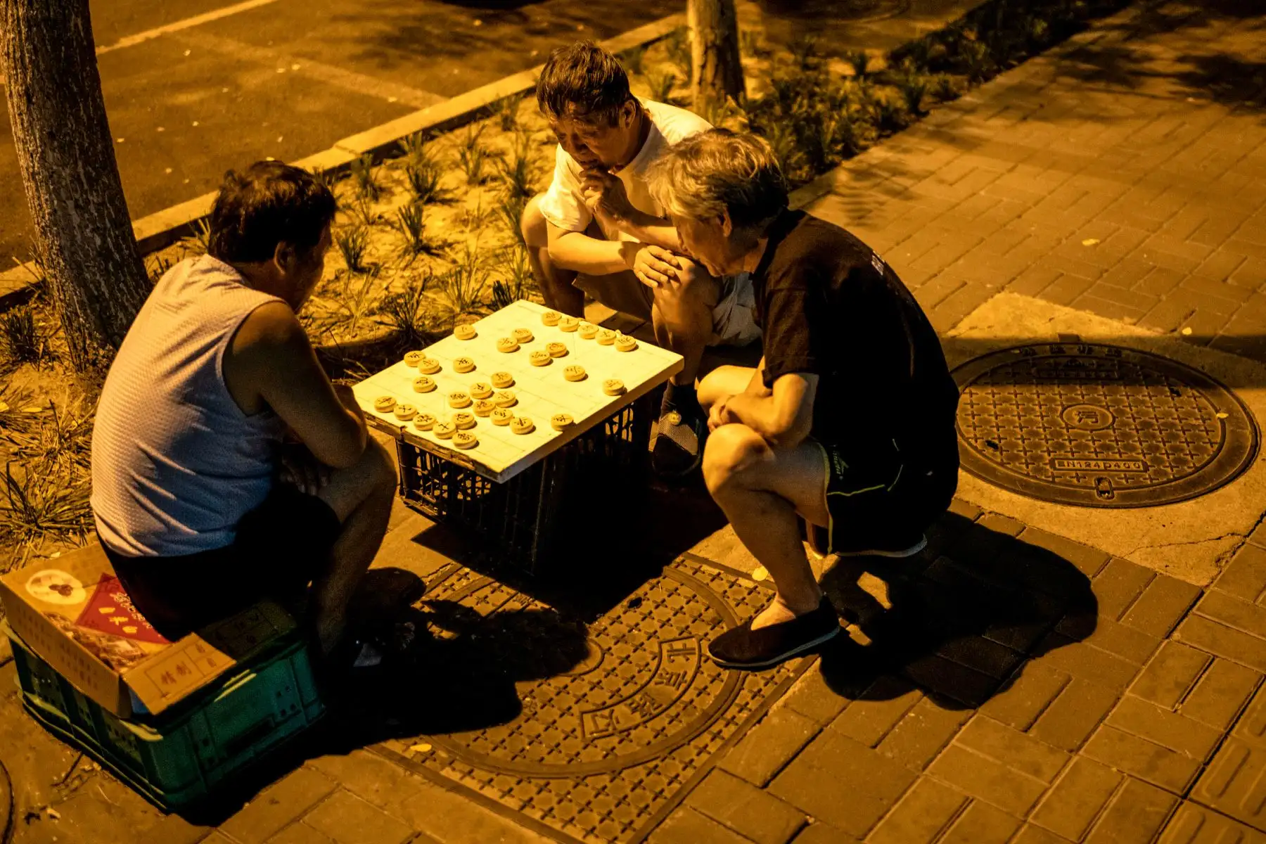 La gente juega un juego de mesa en una calle de Beijing.
Foto: AFP