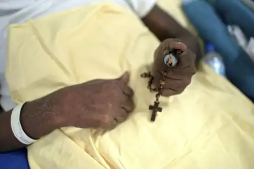 Un paciente con covid-19 sostiene un rosario en la sala posterior del Hospital Universitario Pedro Ernesto en Río de Janeiro, Brasil, en medio de la pandemia del nuevo coronavirus. Foto: AFP
