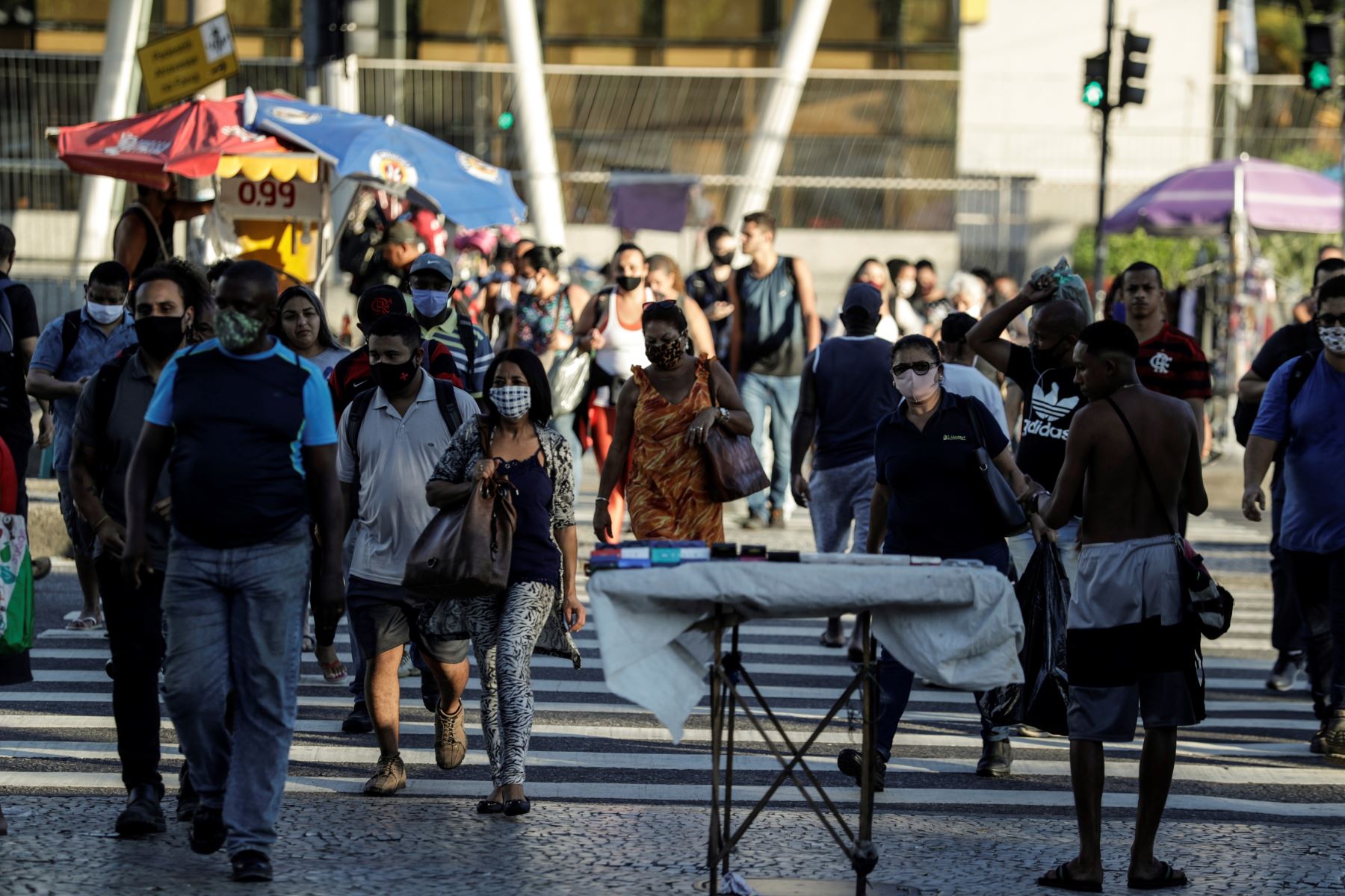 Personas con mascarillas para prevenir la propagación del coronavirus cruzan una calle en Río de Janeiro.
Foto: EFE