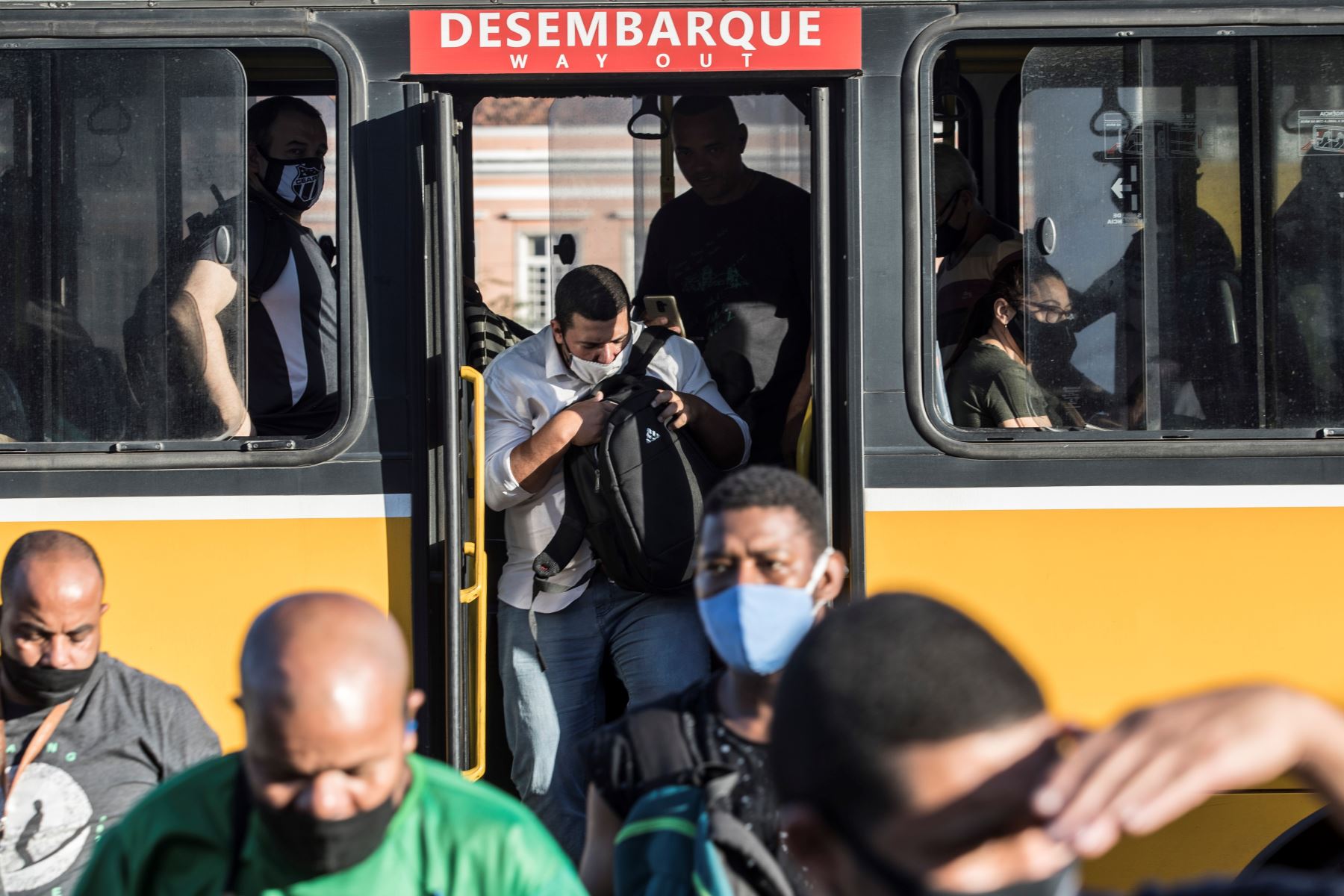 Pasajeros con mascarillas para prevenir la propagación del coronavirus descienden de un autobús en Río de Janeiro.
Foto: EFE