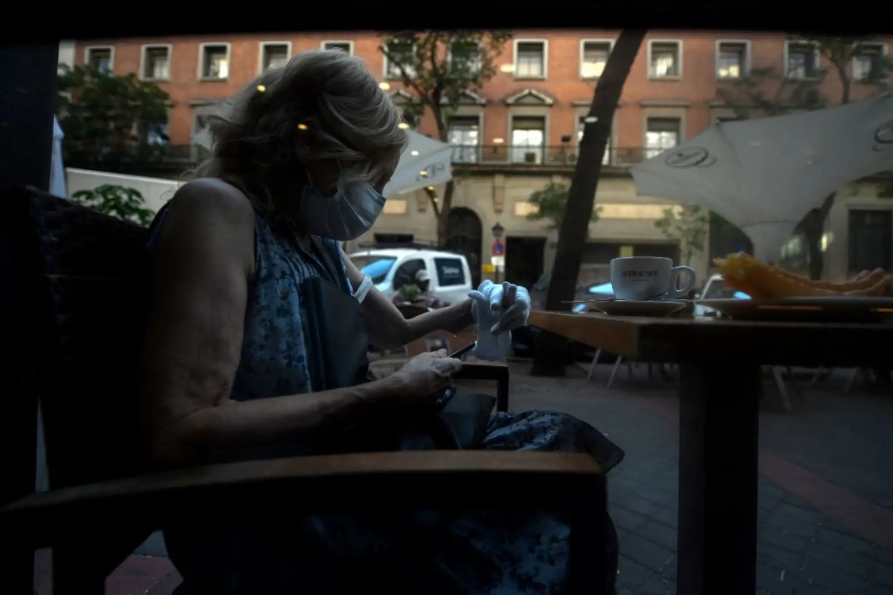 Una mujer que lleva una mascarilla se sienta en un restaurante en Madrid. Foto: AFP