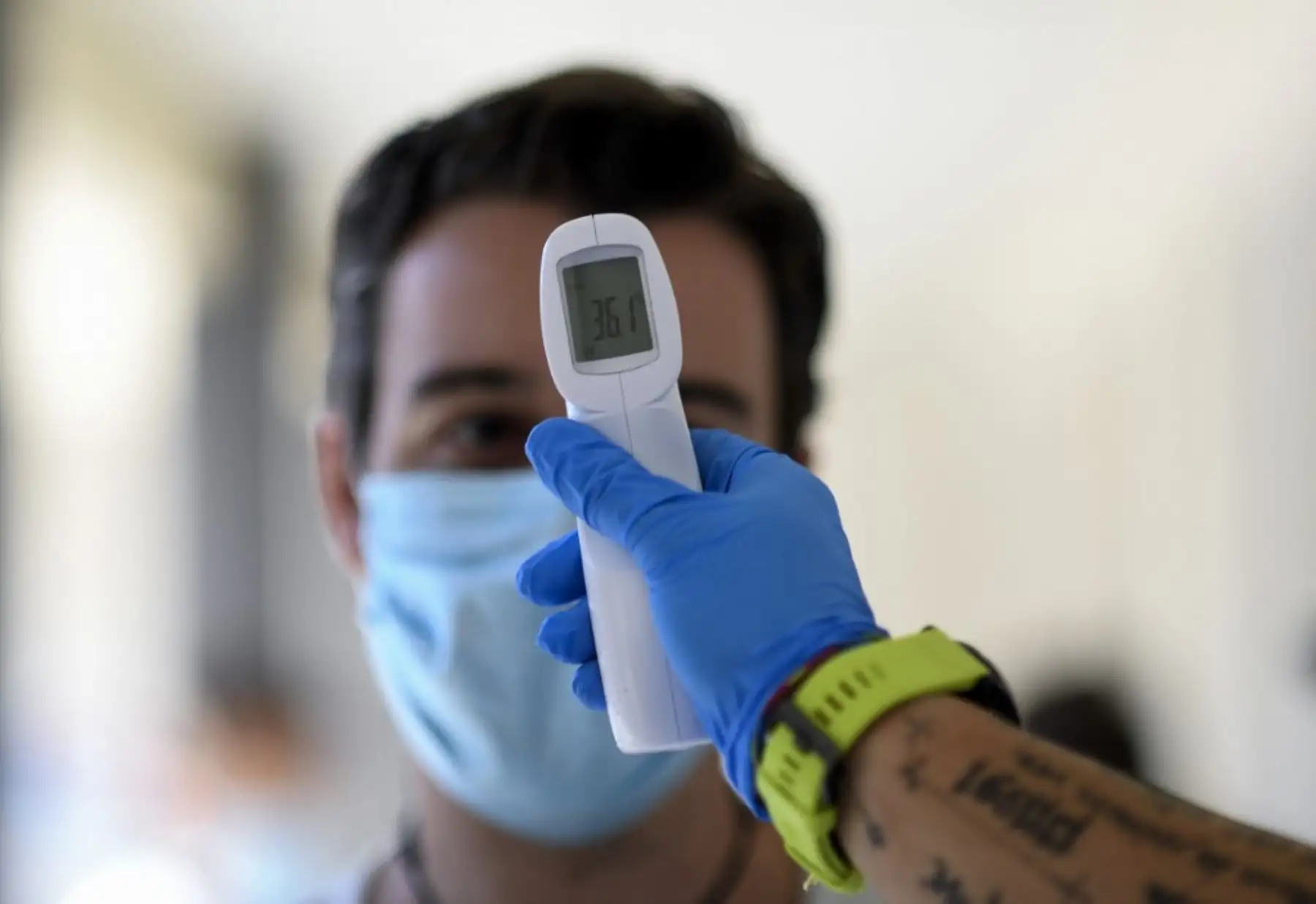 Un trabajador de la salud le toma la temperatura a un hombre en un centro de pruebas temporal para el nuevo coronavirus en Madrid. Foto: AFP