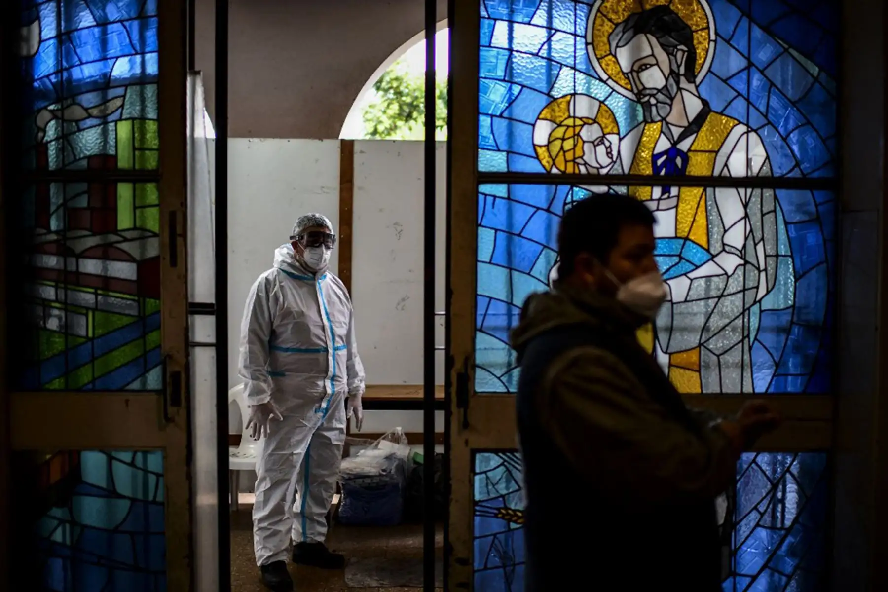Un trabajador de la salud es fotografiado antes de una misa dentro de la iglesia cerrada de San Cayetano en Buenos Aires. Foto: AFP