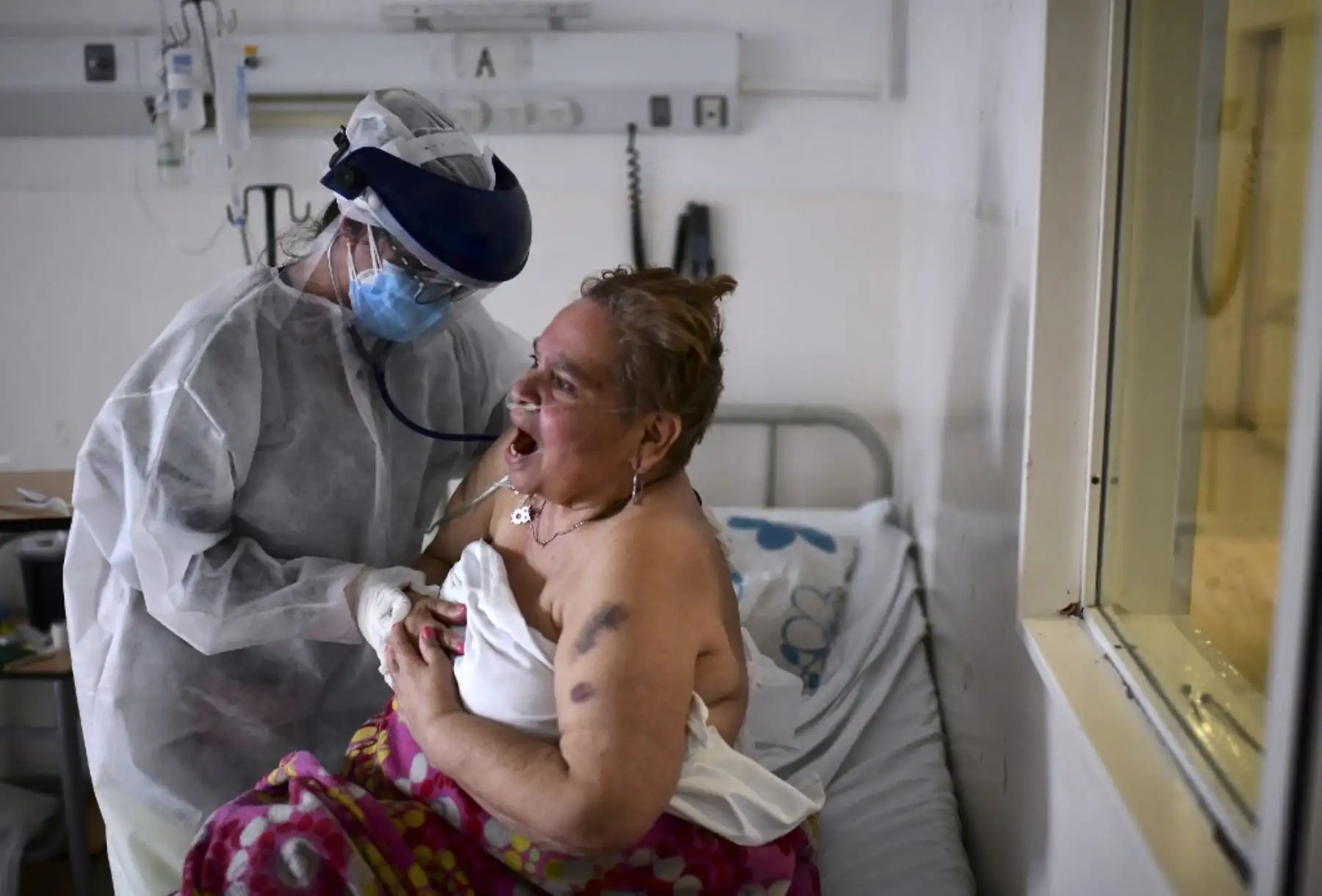Una paciente infectada por el nuevo coronavirus, es atendida por la doctora Analia Mondo, en el Hospital Público Doctor Alberto Antranik Eurnekian de Ezeiza, en las afueras de Buenos Aires. Foto: AFP