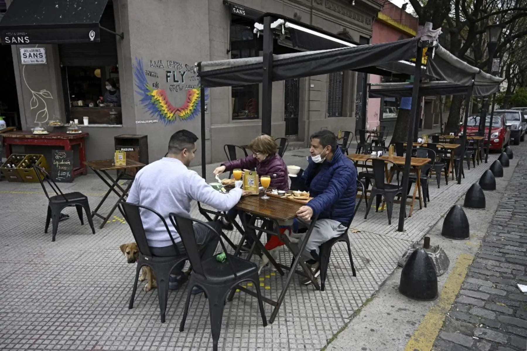 Los clientes desayunan en una mesa colocada en la acera afuera de un café en Buenos Aires, Argentina. Foto: AFP