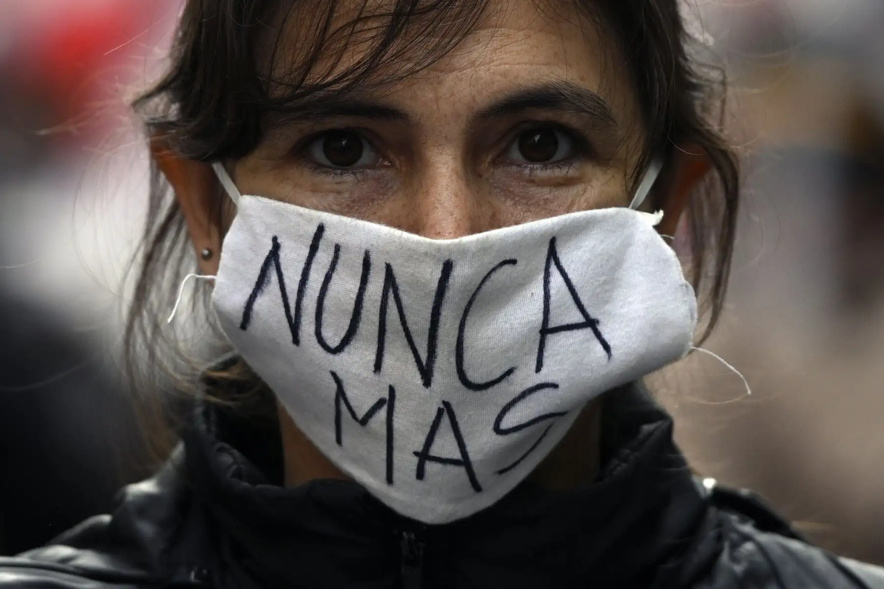 Una mujer lleva una máscara que dice "Nunca más" mientras marchaba hacia la Plaza de Mayo en Buenos Aires. Foto: AFP