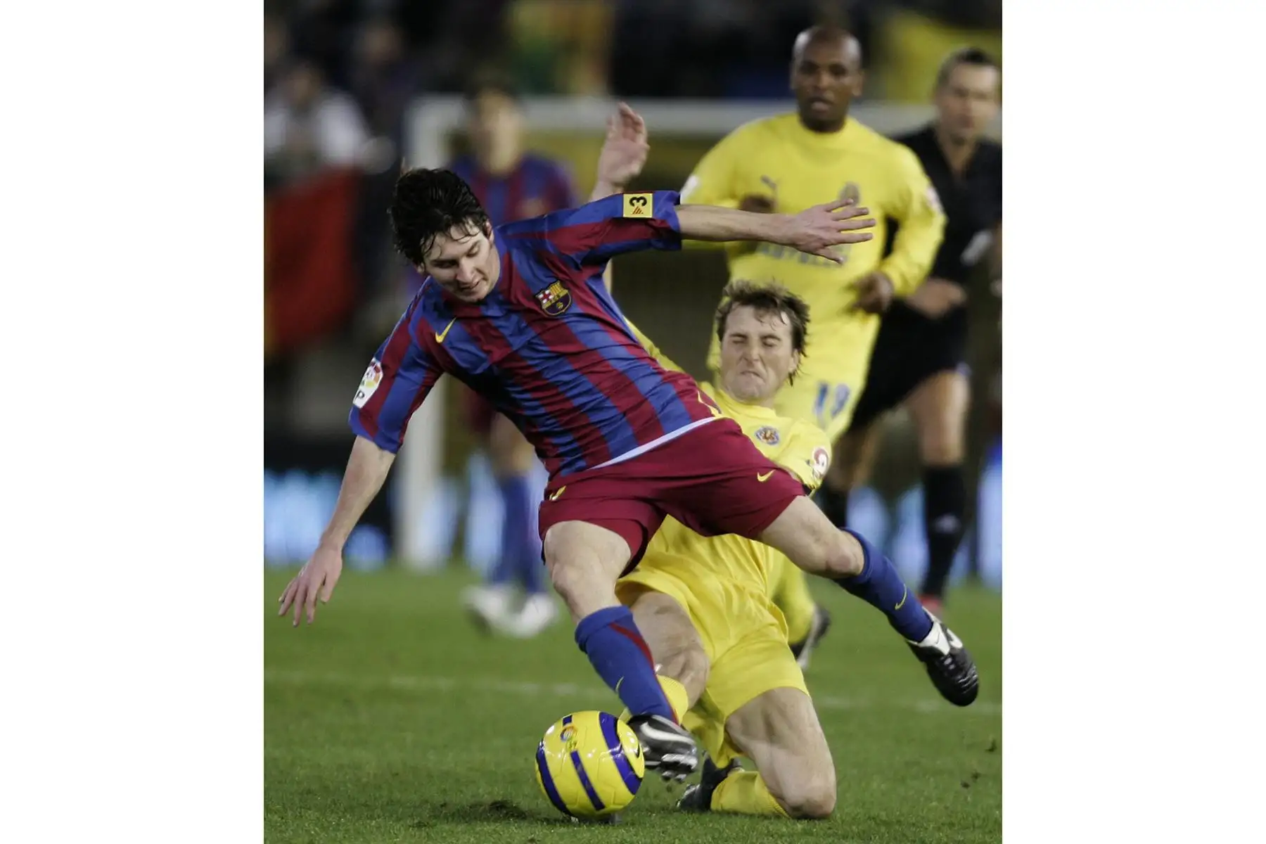 Josico Moreno del Villarreal, lucha por el balón con el argentino Lionel Messi del Barcelona durante su partido de Liga española en el estadio Madrigal de Villarreal, el 04 de diciembre de 2005. Foto: AFP