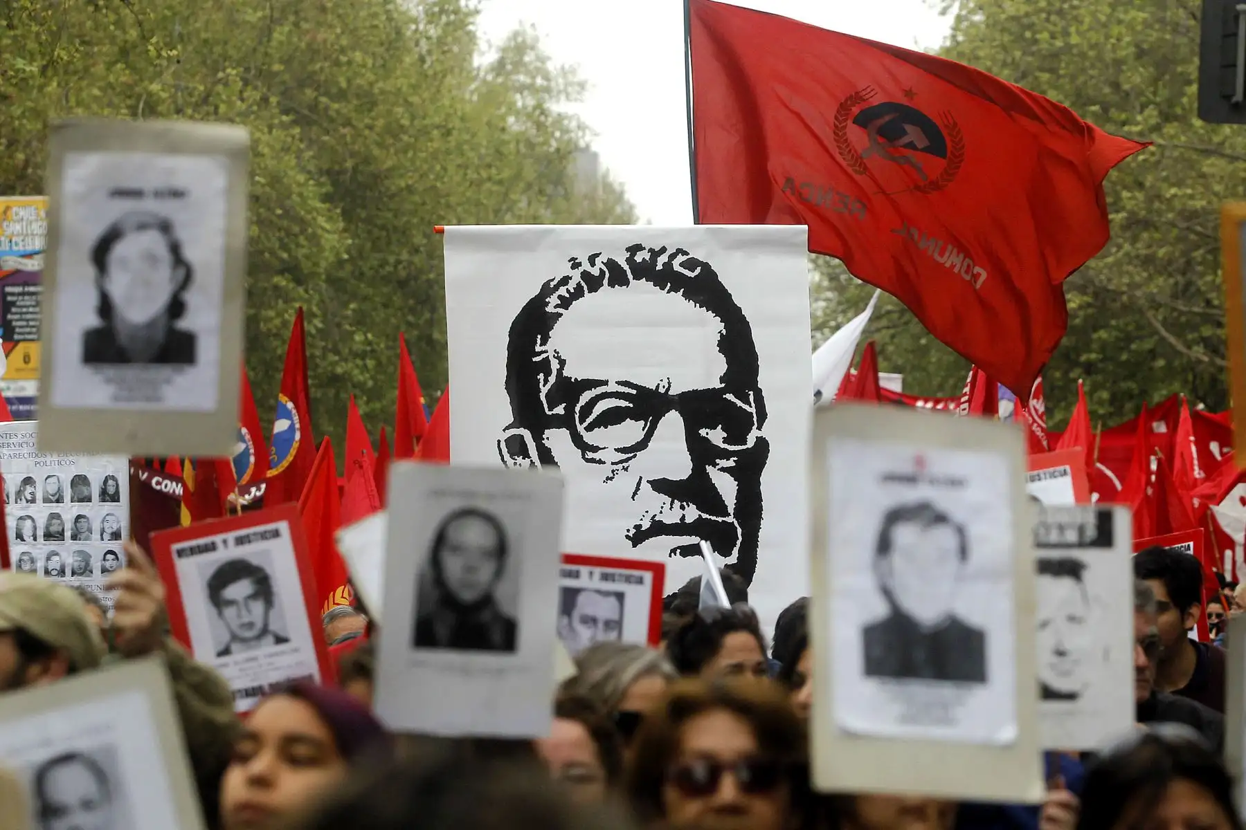 Activistas de derechos humanos con fotografías de personas desaparecidas, en la que se ve la imagen del expresidente de Chile Salvador Allende, marchan en Santiago el 11 de septiembre de 2016, en la conmemoración del 43 aniversario del golpe militar encabezado por el general Augusto Pinochet que depuso al presidente Salvador Allende. Foto: AFP