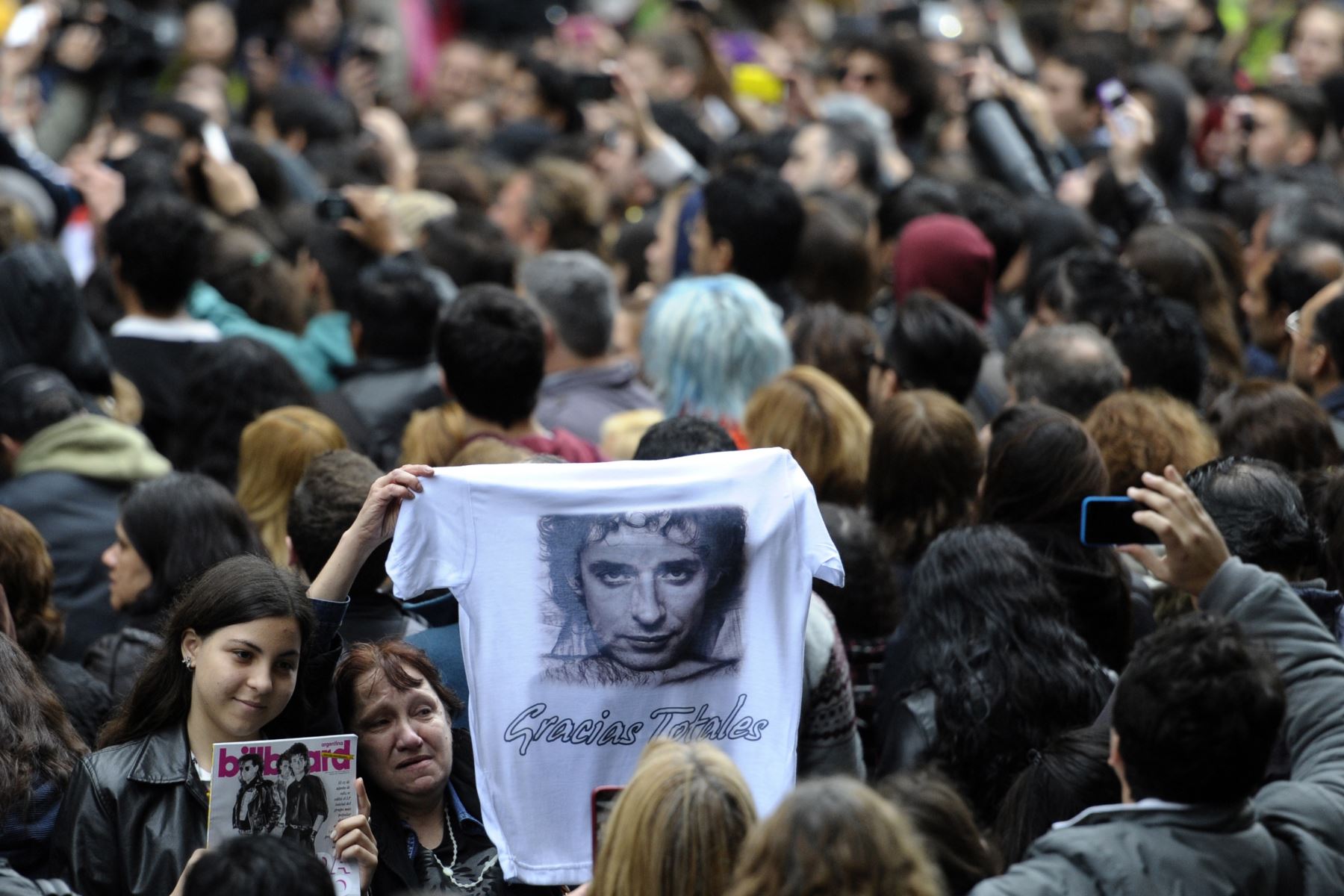 Un fanático sostiene una camisa con el retrato del fallecido músico argentino Gustavo Cerati durante su funeral en Buenos Aires el 5 de septiembre de 2014. Foto.AFP