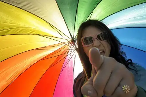 Un transexual hace gestos bajo un paraguas de arcoíris durante la XVIII Marcha del Orgullo Gay en Buenos Aires el 7 de noviembre de 2009. Foto: AFP