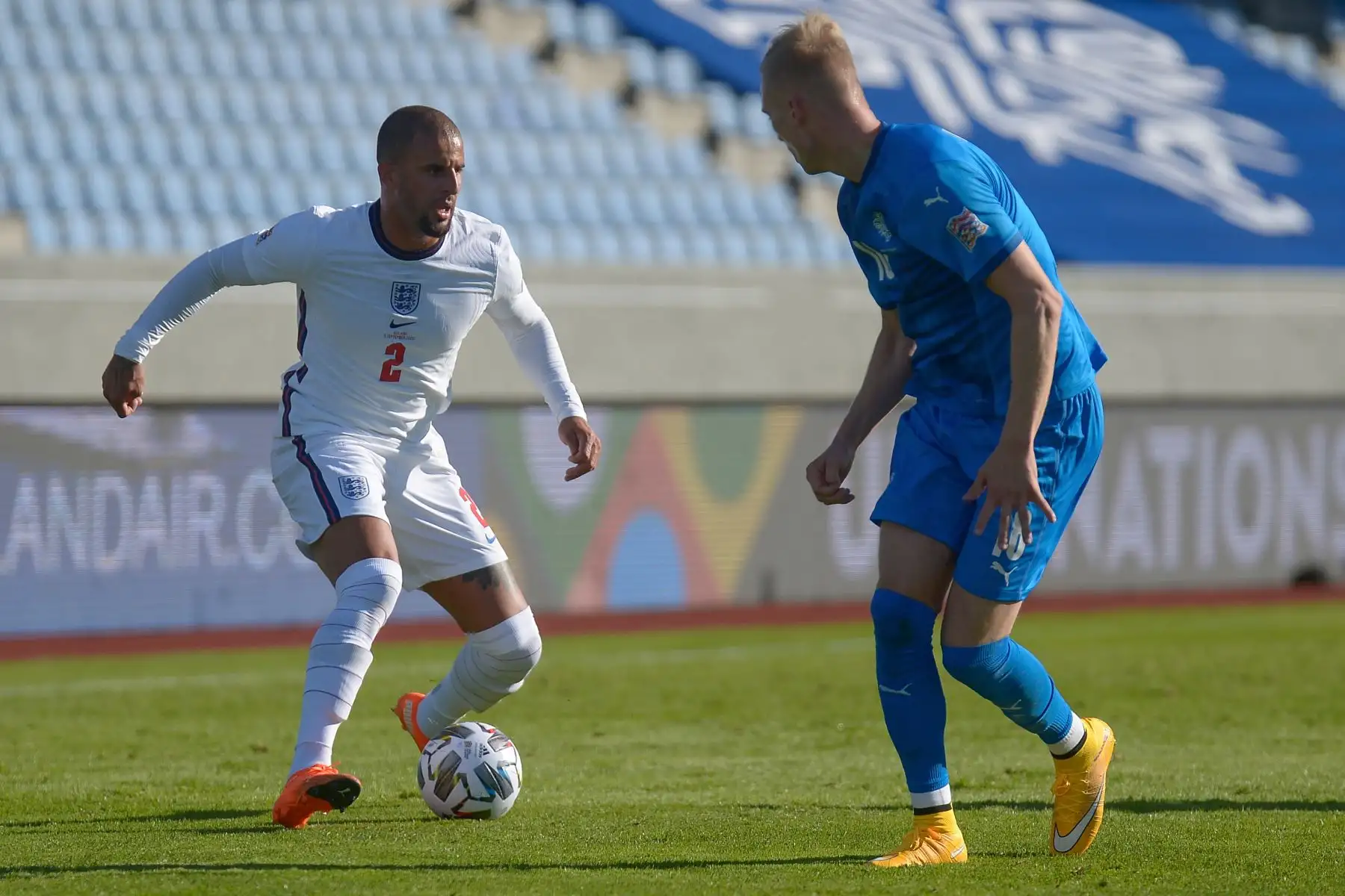 El defensor de Inglaterra Kyle Walker  y el defensor de Islandia, Hordur Magnusson, compiten por el balón durante el partido de fútbol de la Liga de Naciones de la UEFA, en Reykjavik. Foto: AFP