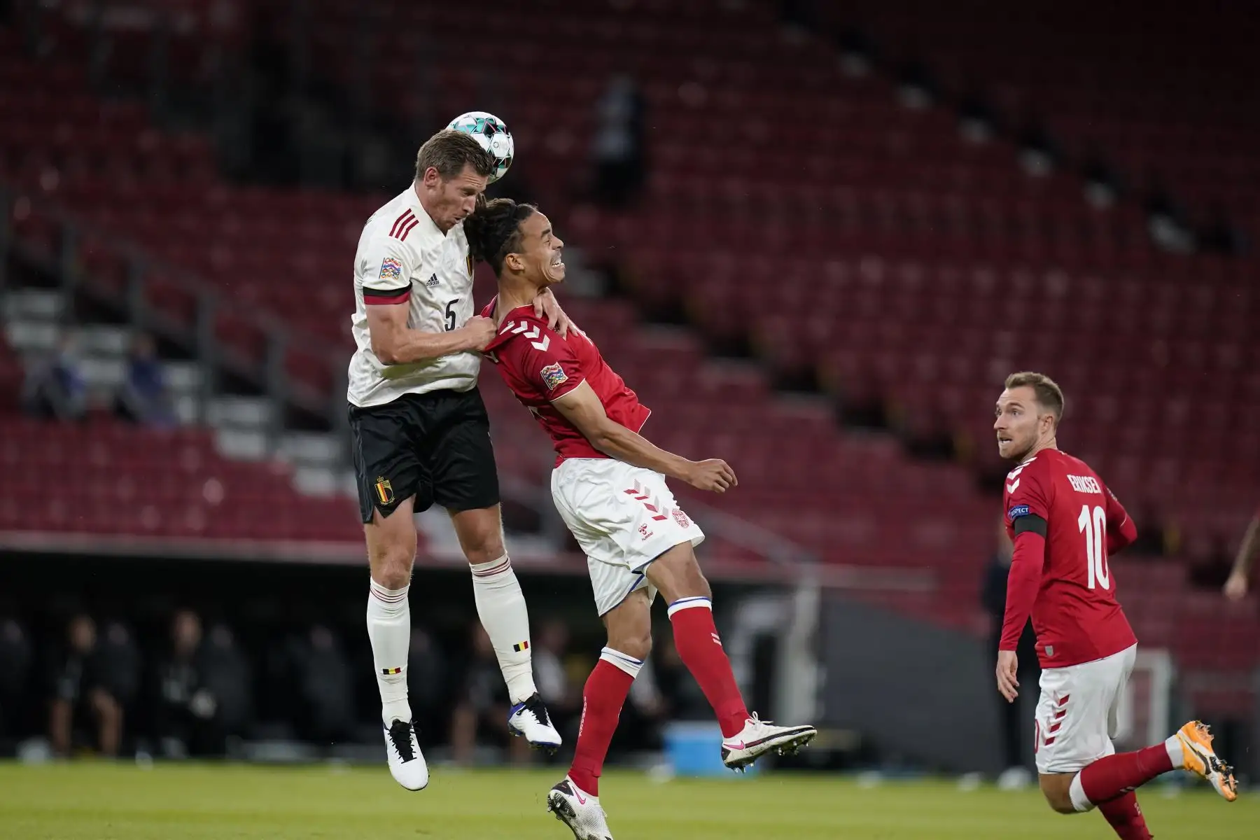 El defensor de Bélgica Jan Vertonghen y el delantero de Dinamarca Yussuf Poulsen saltan para cabecear el durante el partido de fútbol de la liga de Naciones de la UEFA. Foto: AFP