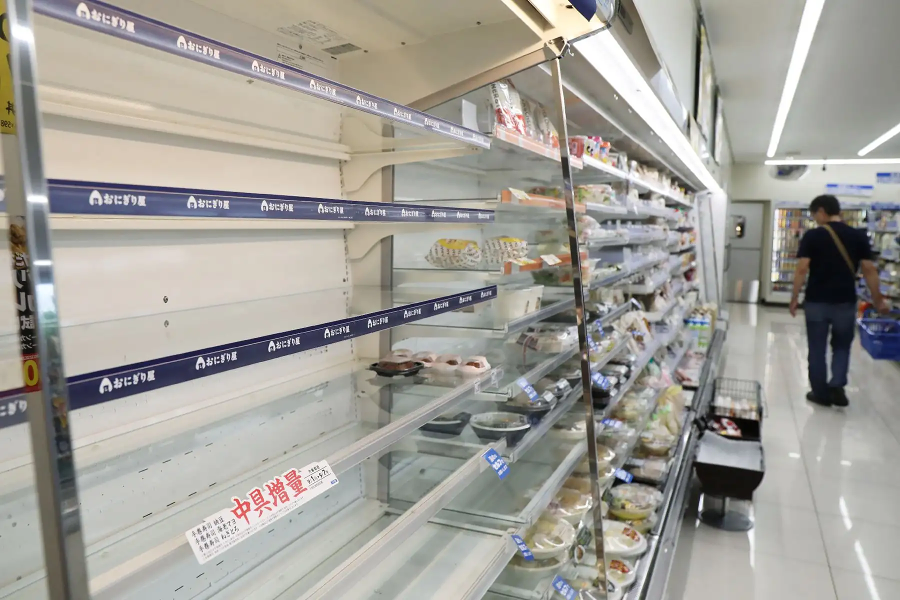 Un hombre compra cerca de los estantes de comida vacíos en una tienda de de Hitoyoshi, prefectura de Kumamoto, el 6 de septiembre de 2020, mientras se emiten alertas de evacuación debido a la proximidad del tifón Haishen. Foto: AFP