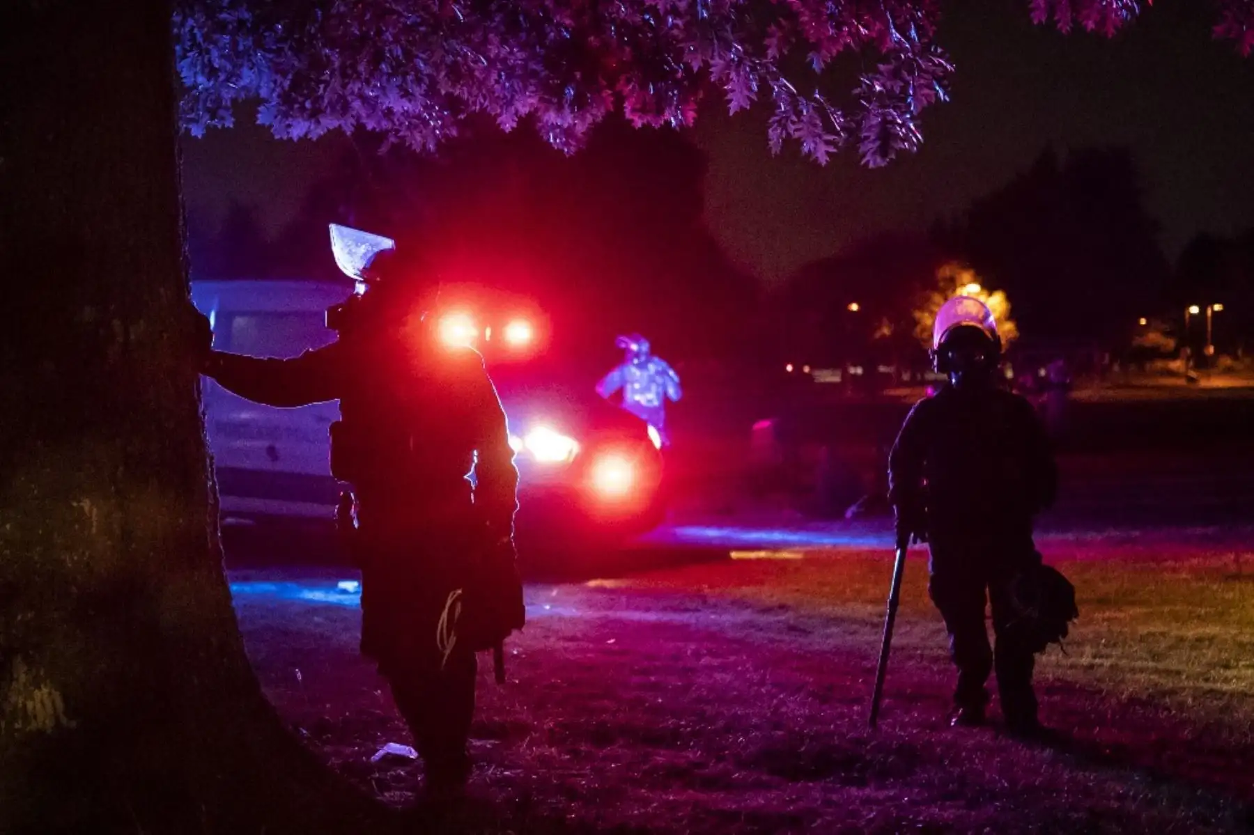 Los agentes del estado de Oregon descansan contra un árbol cerca del final de una protesta contra la brutalidad policial y la injusticia racial temprano en Portland, Oregon. Foto: AFP