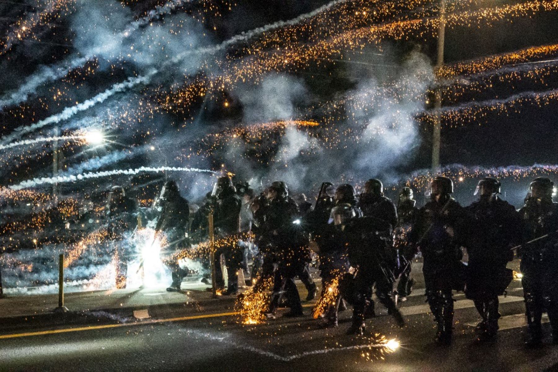 Los agentes del estado de Oregon y la policía de Portland avanzan a través de gas lacrimógeno y bomberos mientras dispersan una protesta contra la brutalidad policial y la injusticia racial en Portland, Oregon. Foto: AFP