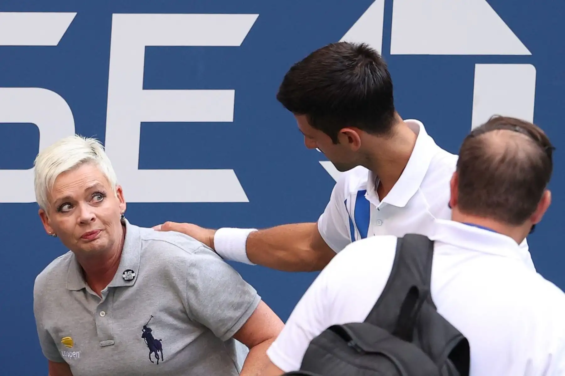 El tenista serbio, Novak Djokovic, atiende a una juez de línea que fue golpeada, sin intención, con la pelota por el propio jugador durante su partido de cuarta ronda de hombres individuales contra Pablo Carreño Busta de España en el séptimo día del Abierto de Estados Unidos 2020. Por esta acción, el jugador fue descalificado del torneo. Foto: AFP